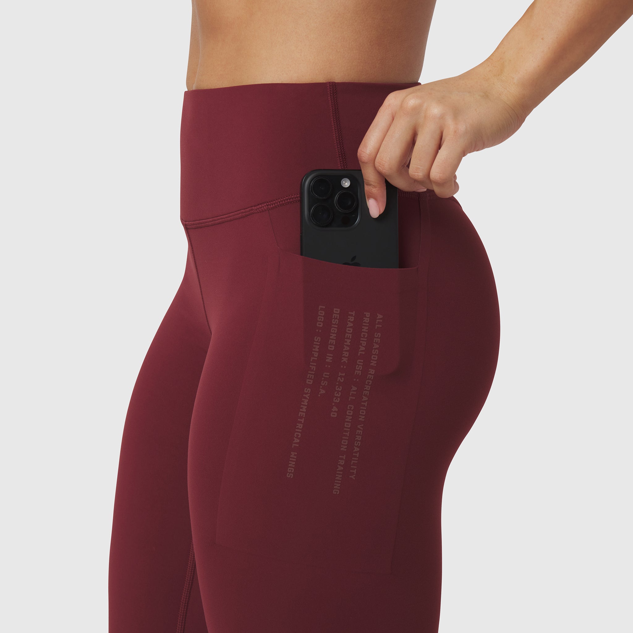 Crimson 4 Pocket Legging worn by model, demonstrating side pocket with phone