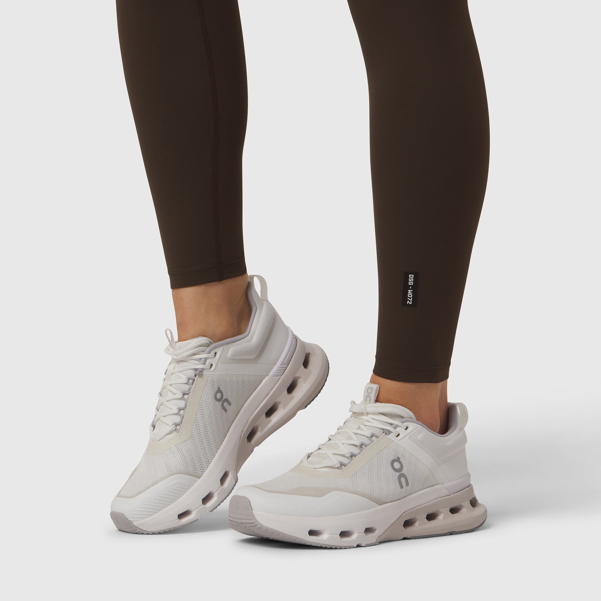 W072 LYCRA® ADAPTIV 4 Pocket Legging in Dark Earth, worn with white sneakers, front view
