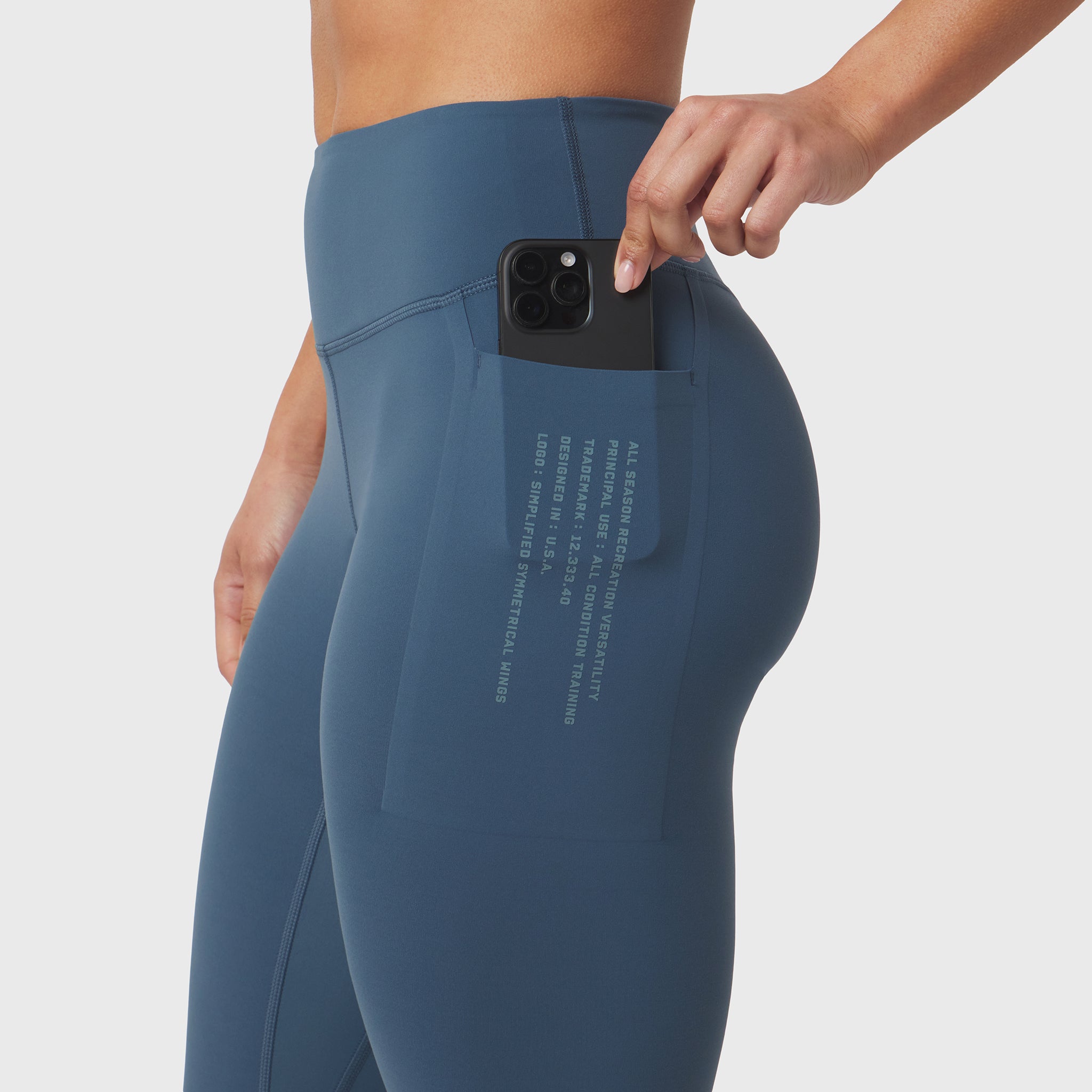 W072 LYCRA® ADAPTIV 4 Pocket Legging in storm blue, worn with phone in pocket, side view