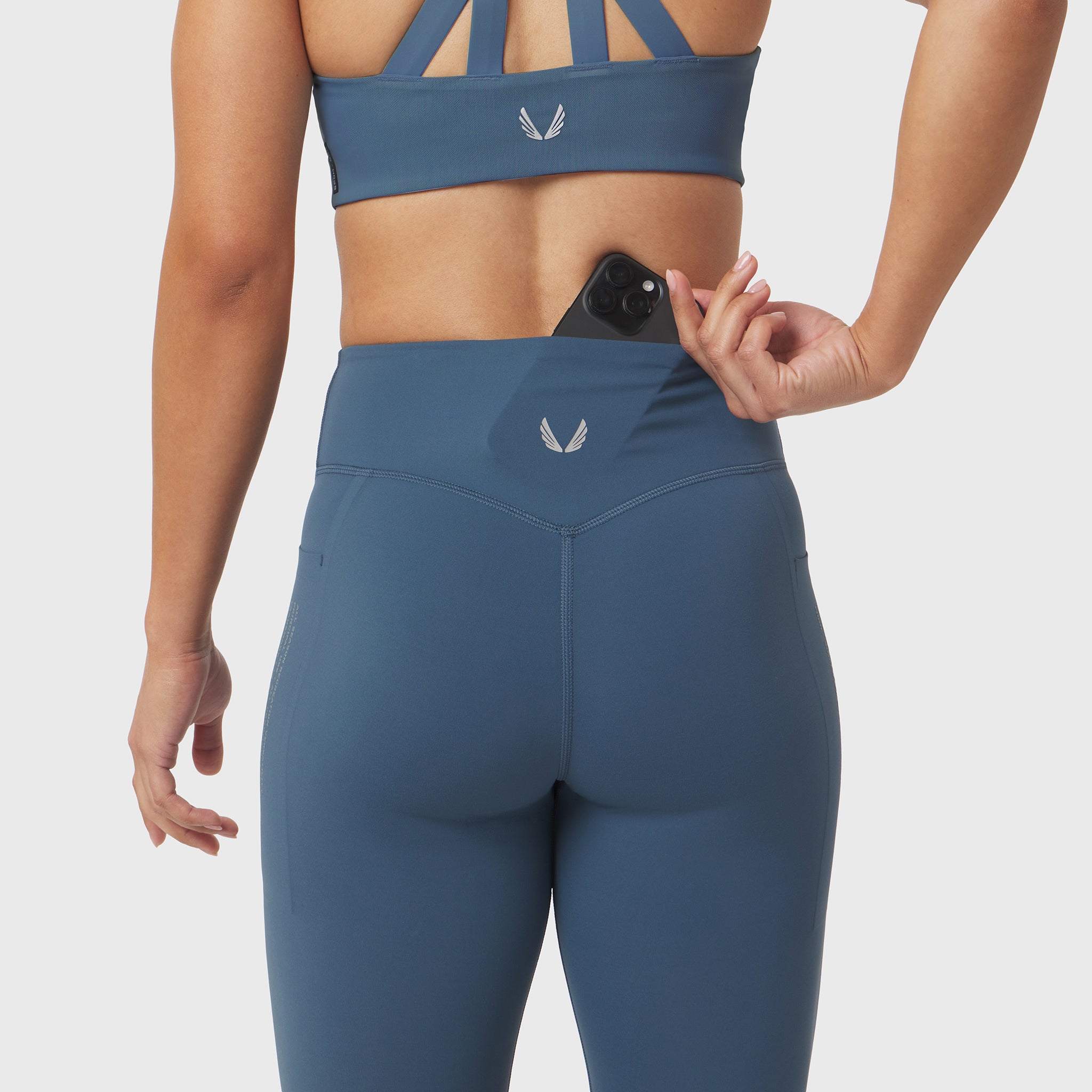 W072 Lycra Adaptiv 4 Pocket Legging in storm blue, worn by model showing back view with phone pocket