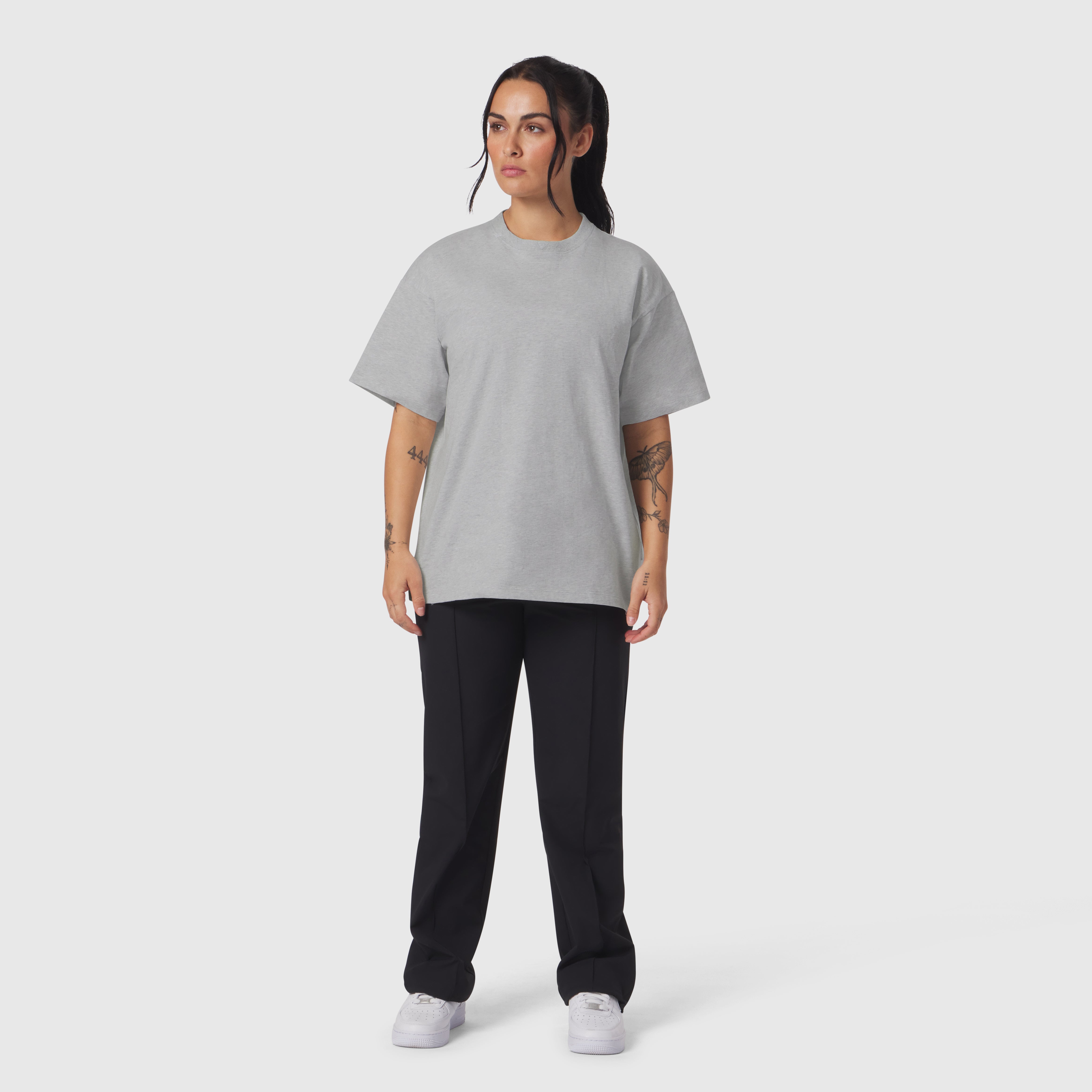 Heather grey relaxed tee worn with black joggers and white sneakers, front view