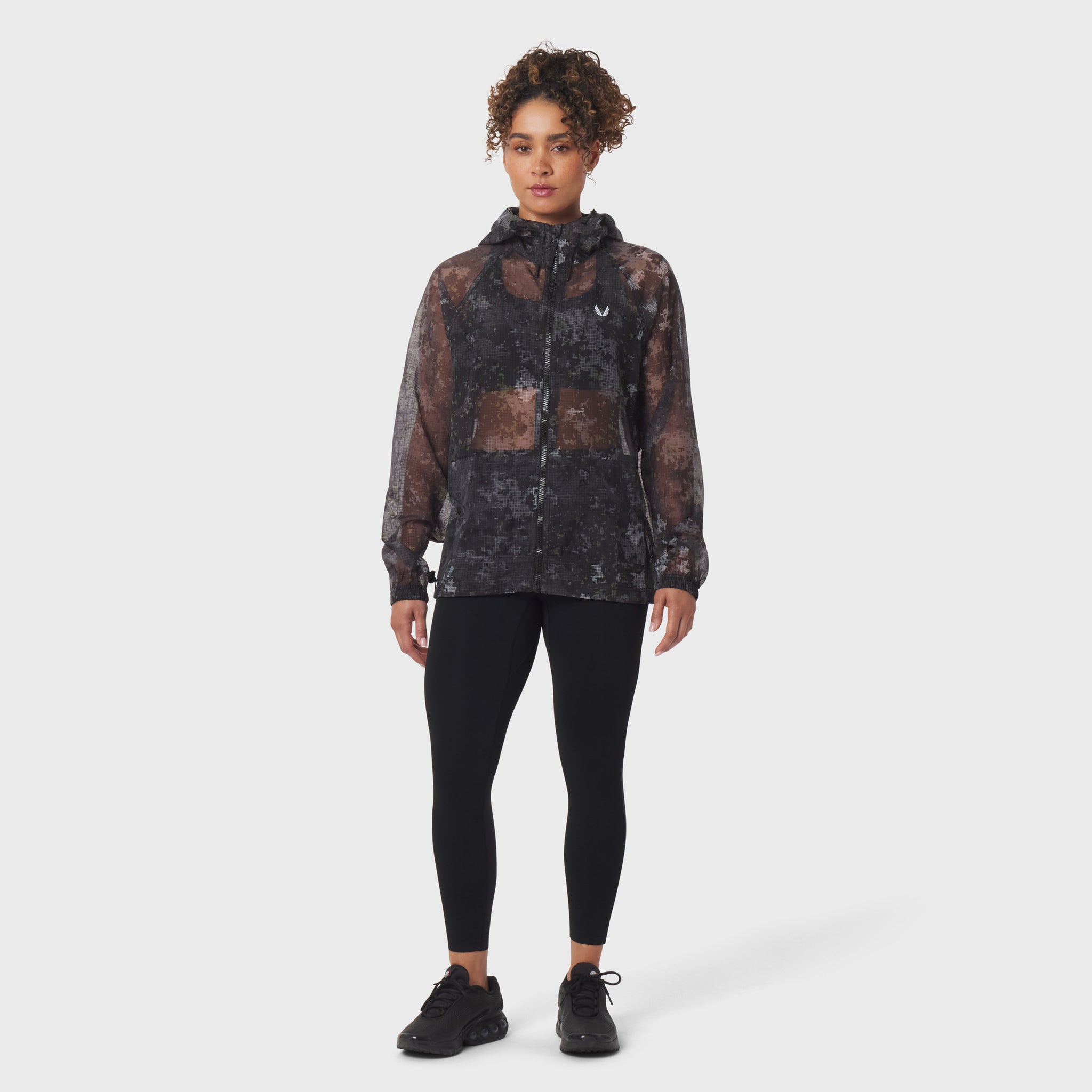 Weather-Ready Transparent Ripstop Shell Jacket in pixel camo, worn with black leggings
