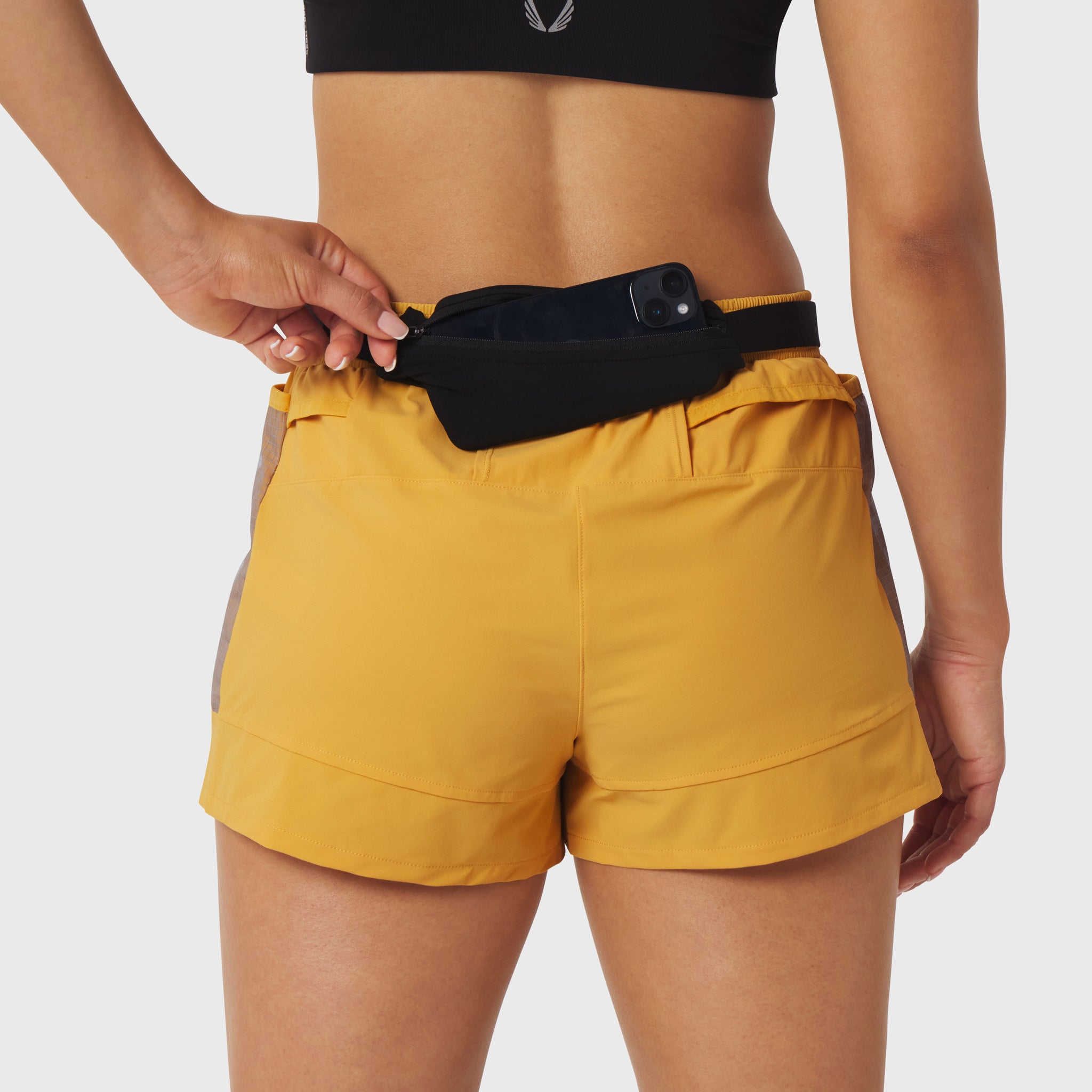 Black Expandable Belt Pack worn on yellow shorts, back view