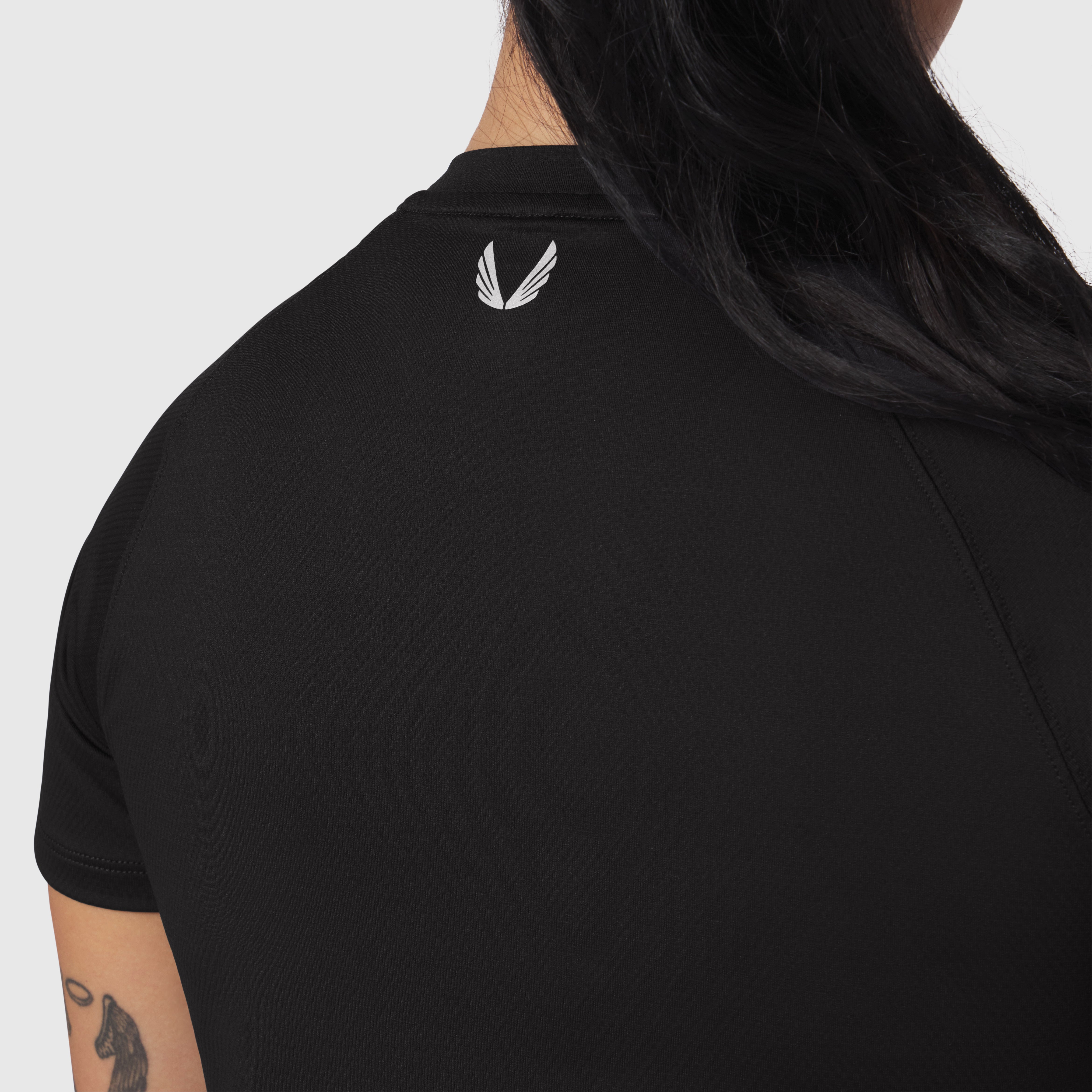 AeroSilver® Cropped Tee in black worn by model, back view showing winged logo