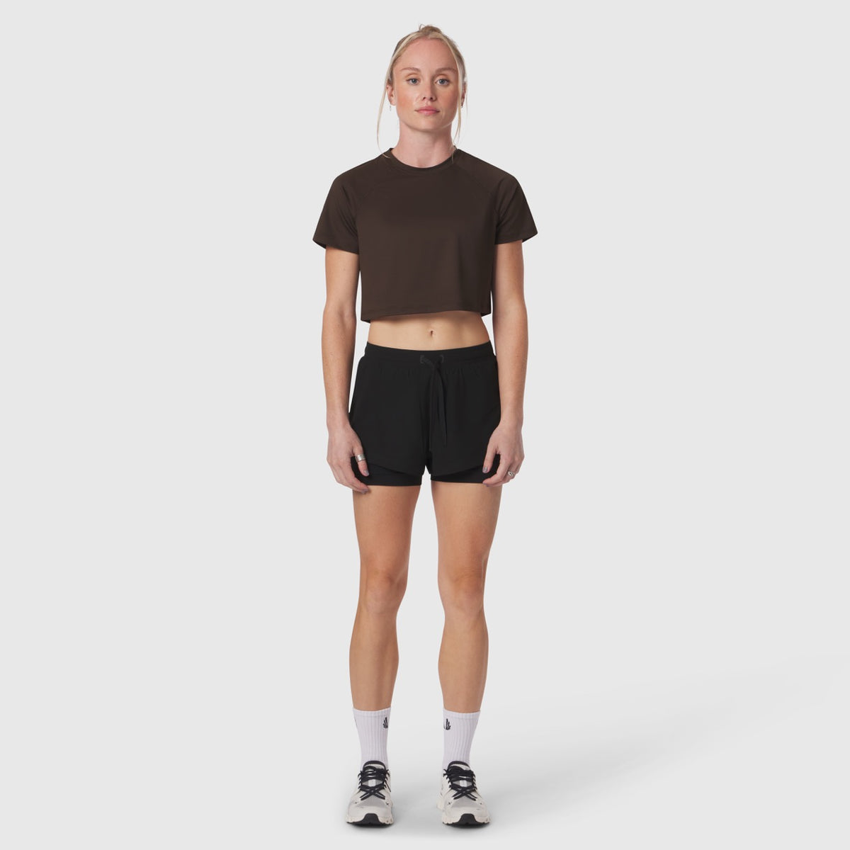 AeroSilver Cropped Tee in dark earth worn with black shorts, front view