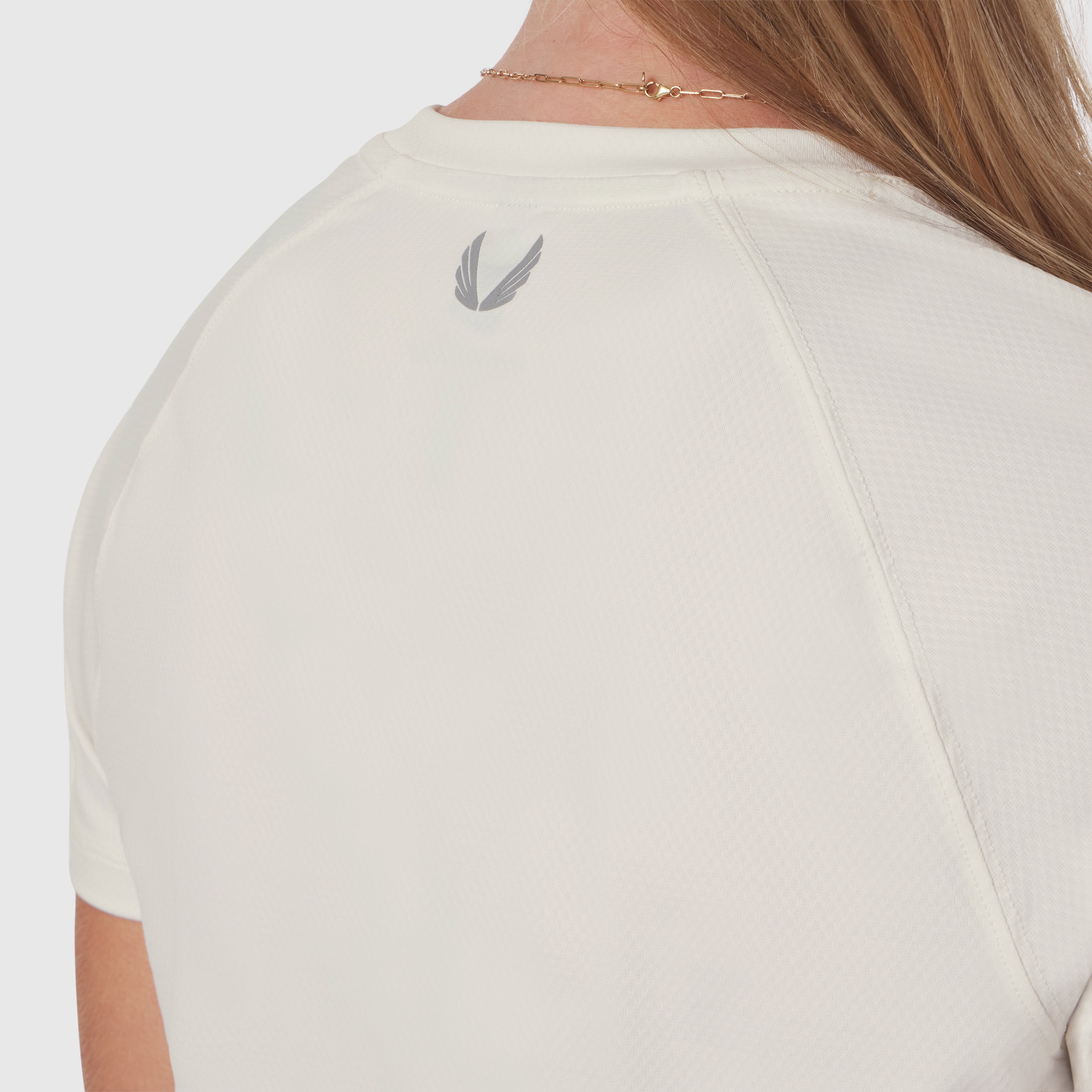 AeroSilver® Cropped Tee in ivory cream worn by model, back view showing feather logo