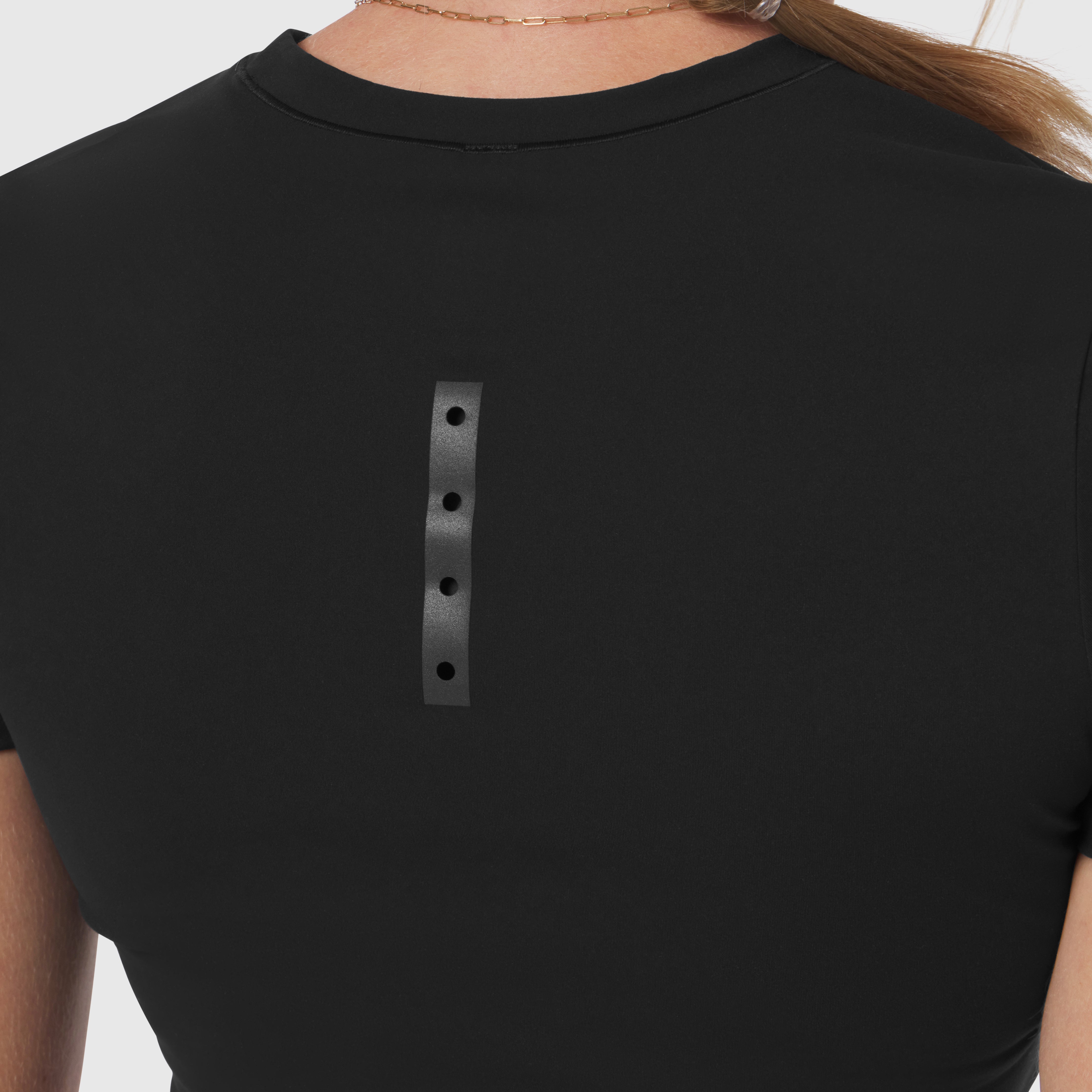Black LYCRA® cropped tee worn by model, back view showing grey reflective strip detail