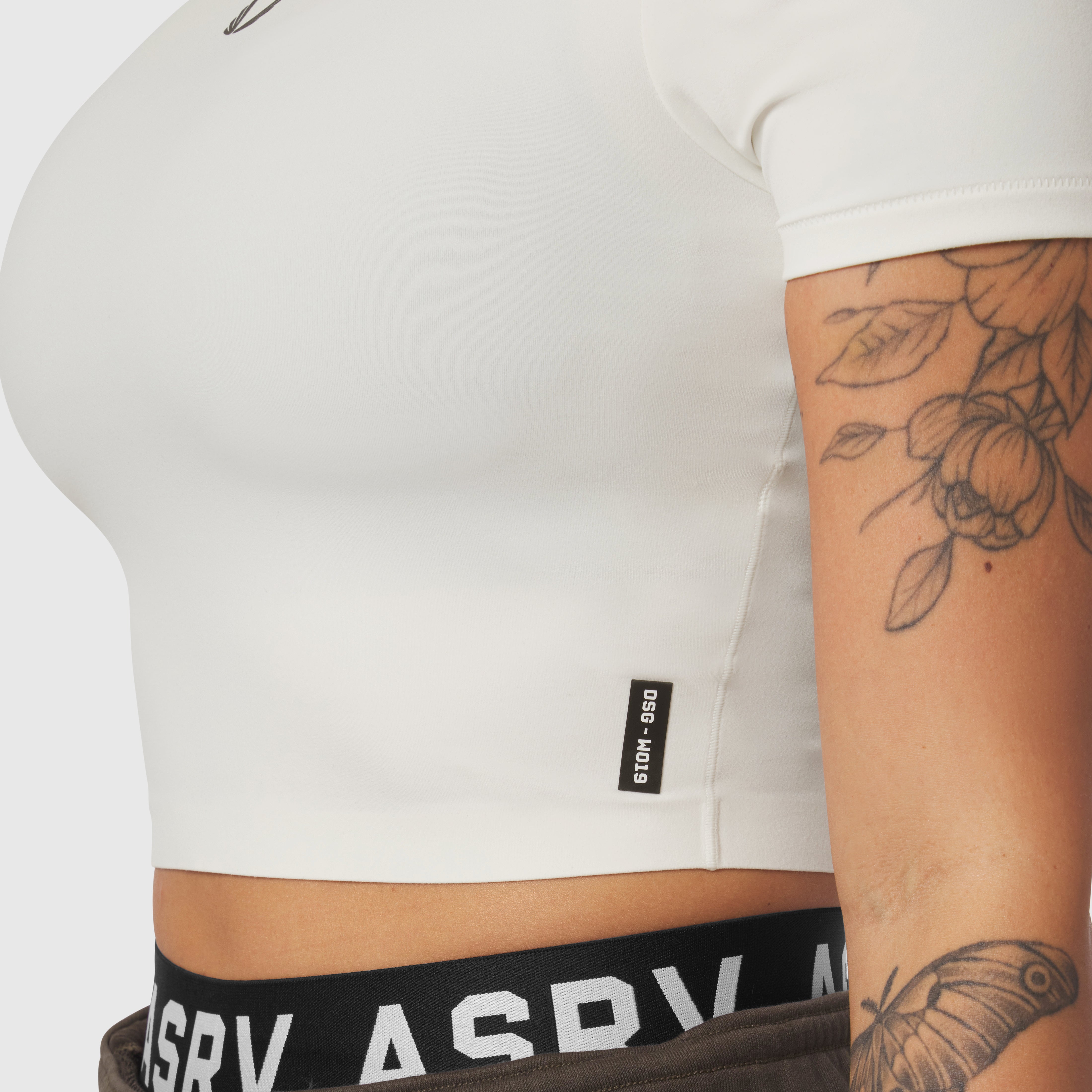 Ivory cream cropped tee worn by model showing fit, side view with visible tattoos