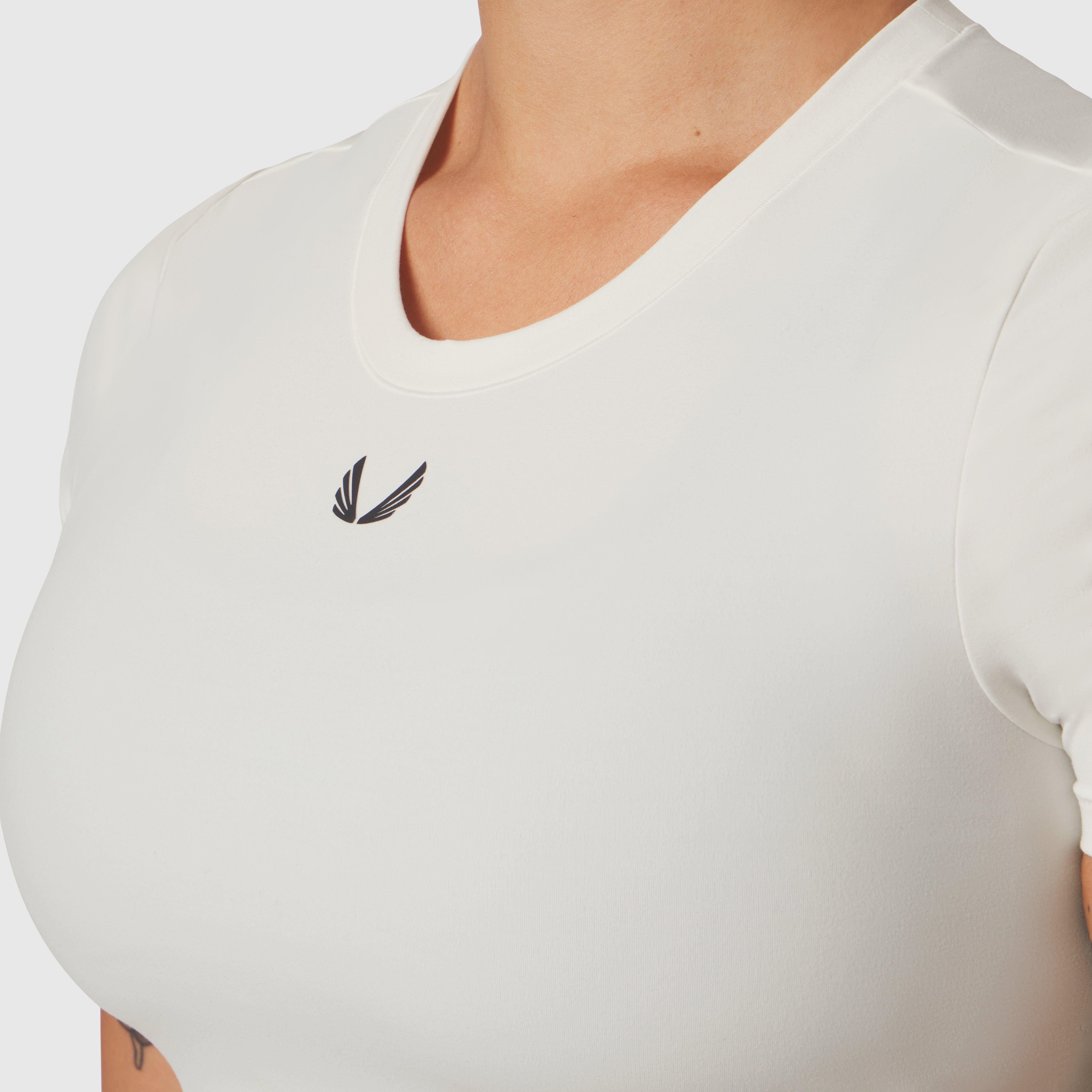 Ivory cream cropped tee with small logo, worn by model, front view