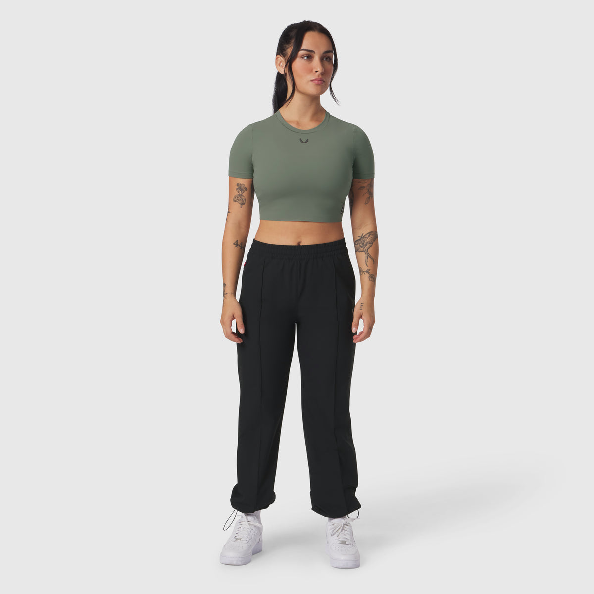 Sage green cropped tee paired with black joggers, modeled with white sneakers