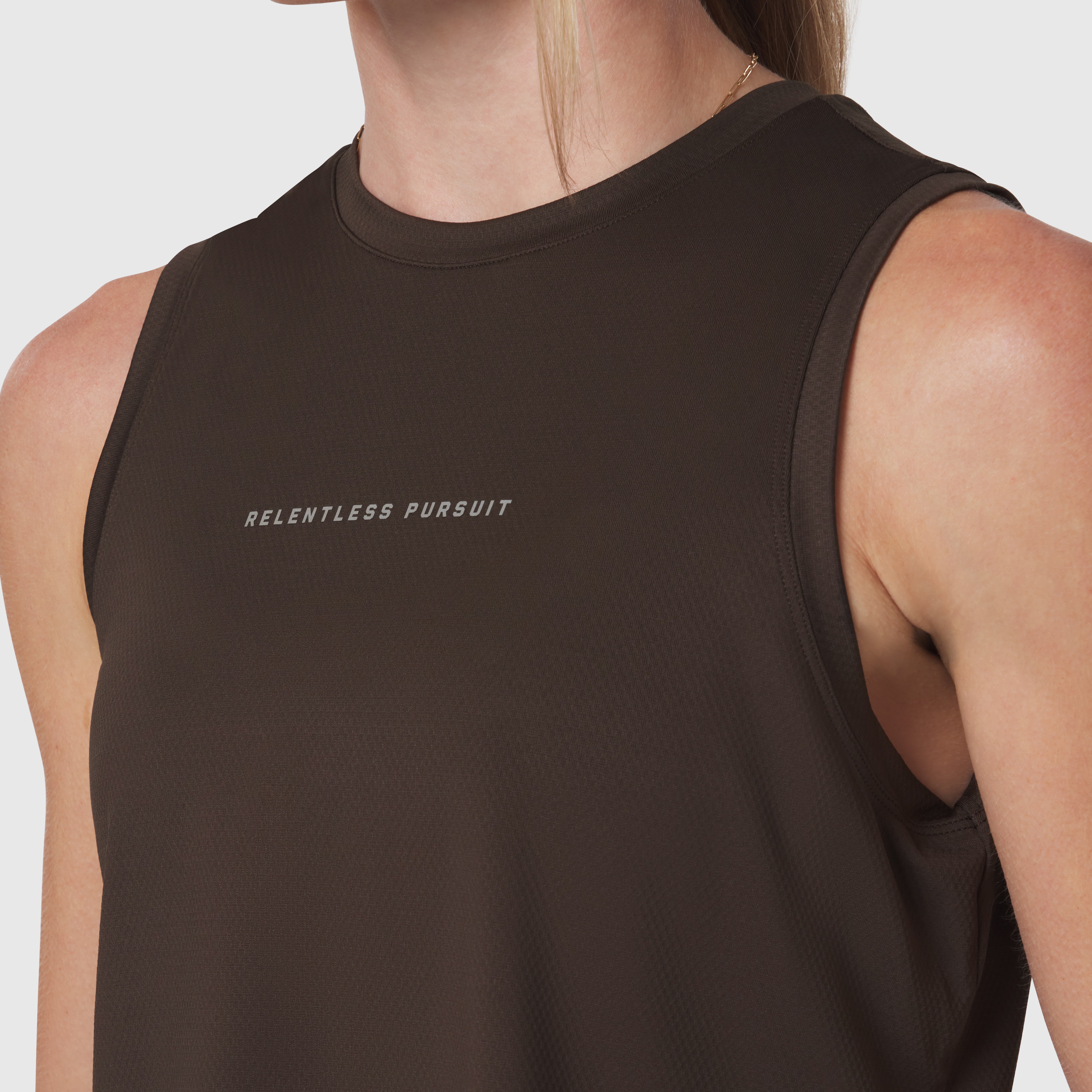 AeroSilver Tank Top in Dark Earth worn by model, front view with 'Relentless Pursuit' text
