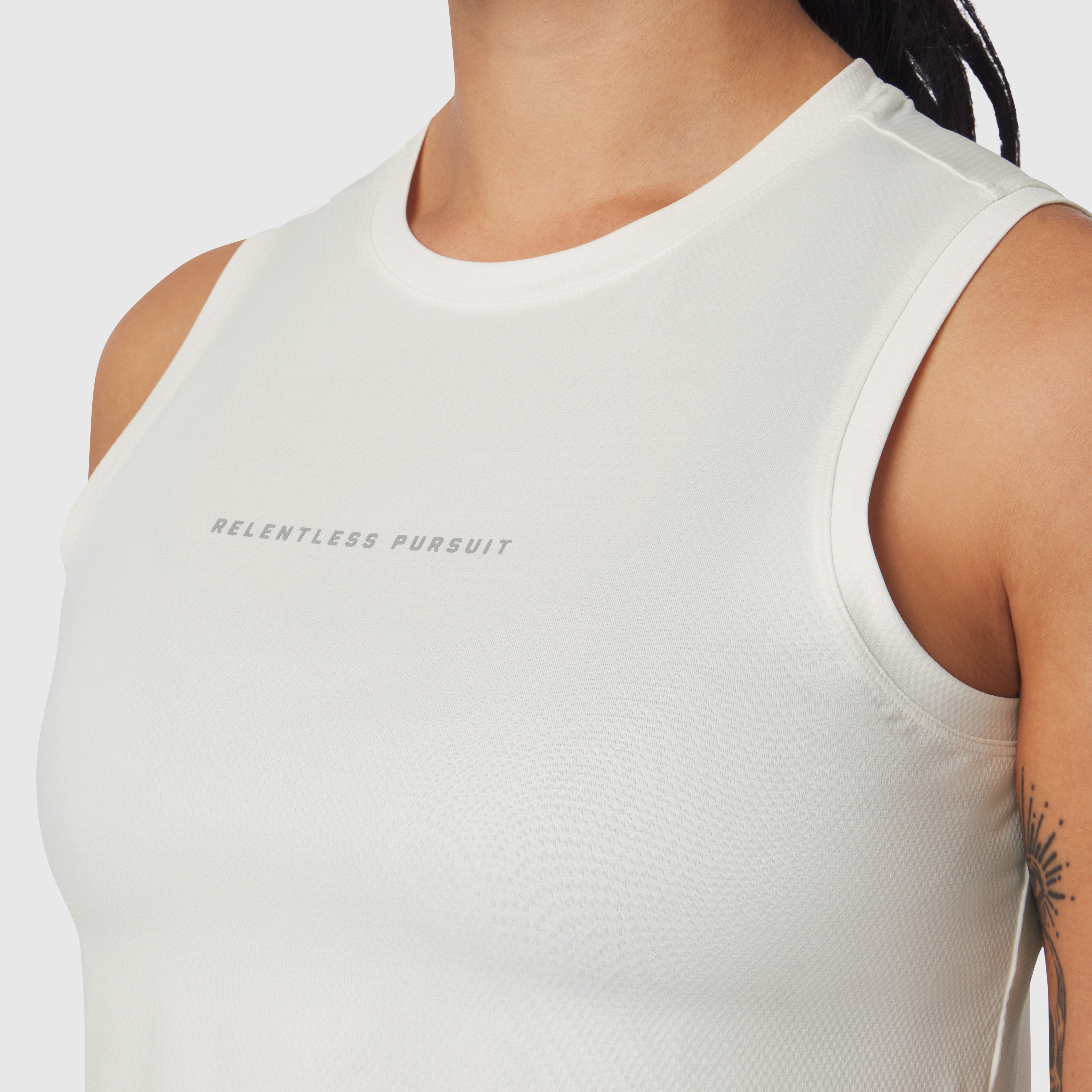 AeroSilver® Tank Top in ivory cream worn by model, front view showing 'Relentless Pursuit' text