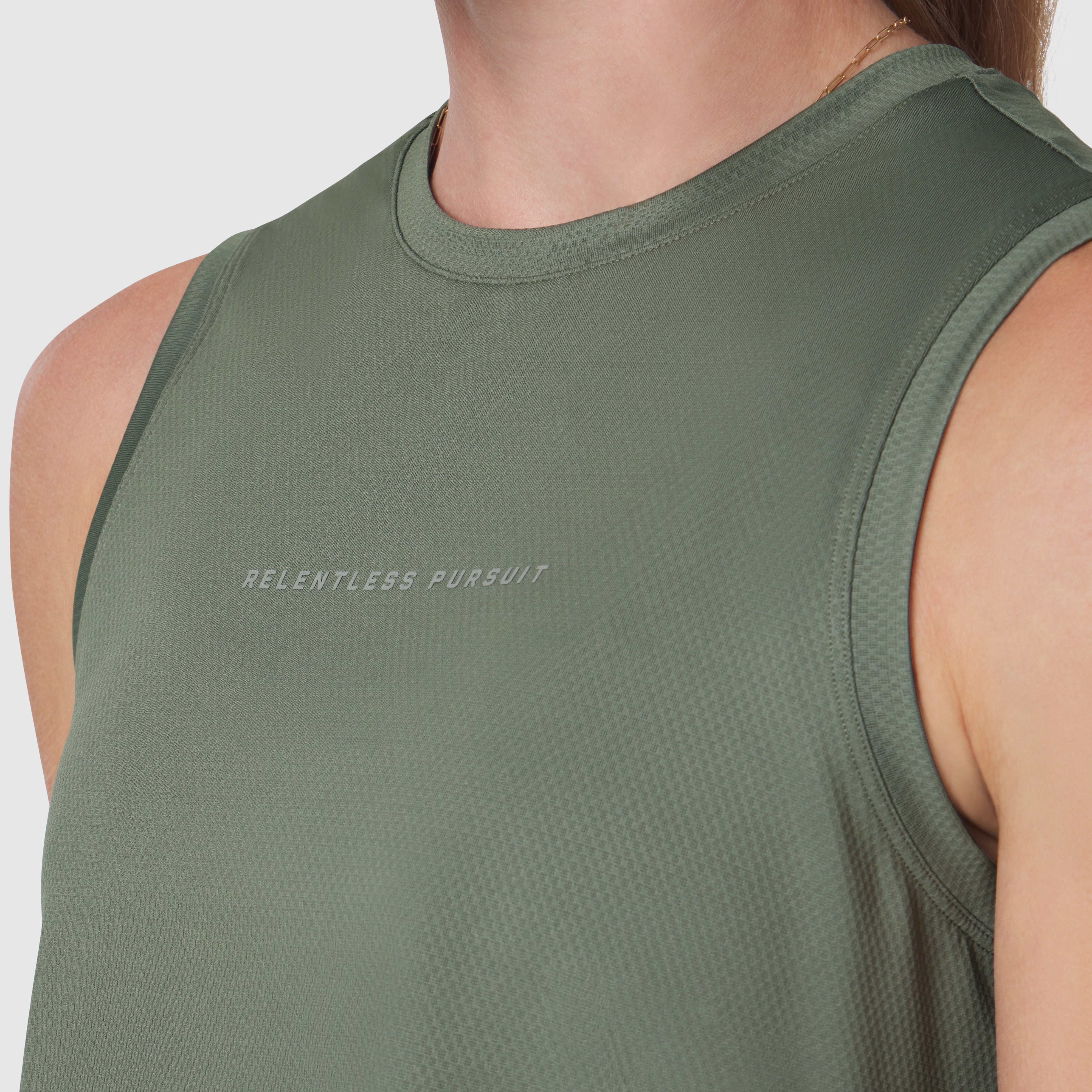 AeroSilver® Tank Top in sage green worn by model, chest detail showing 'Relentless Pursuit' text