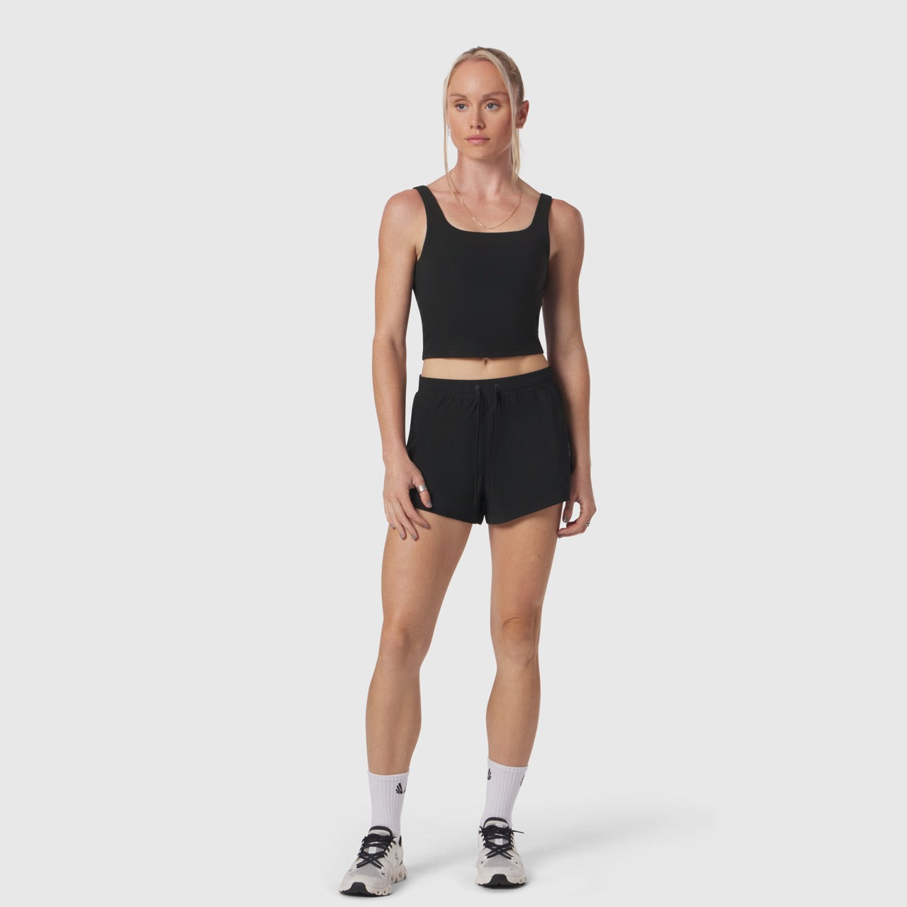 Black LYCRA® 2-in-1 tank top worn by model with matching black shorts, front view