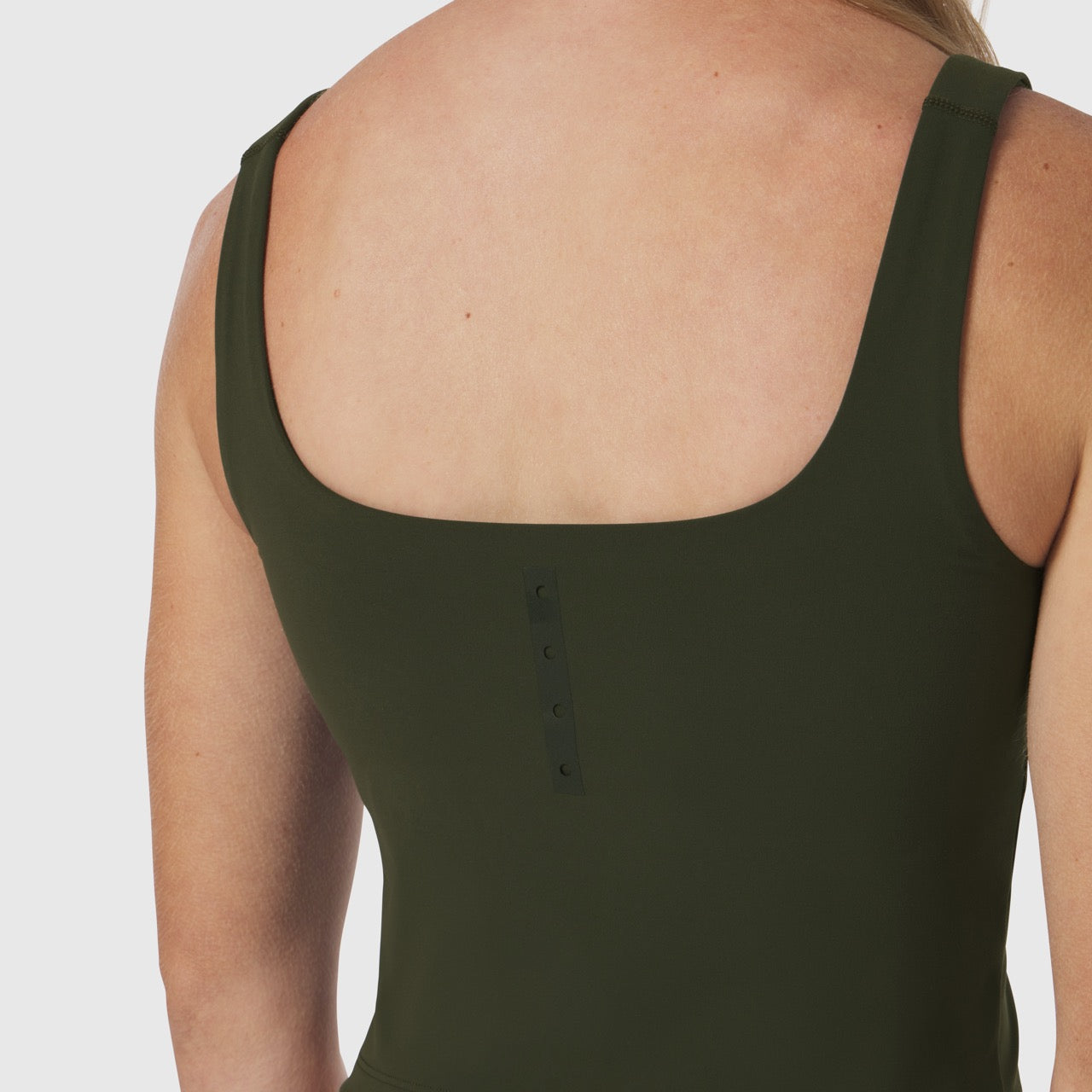 Olive Lycra 2-in-1 tank top worn by model, back view showing button detail