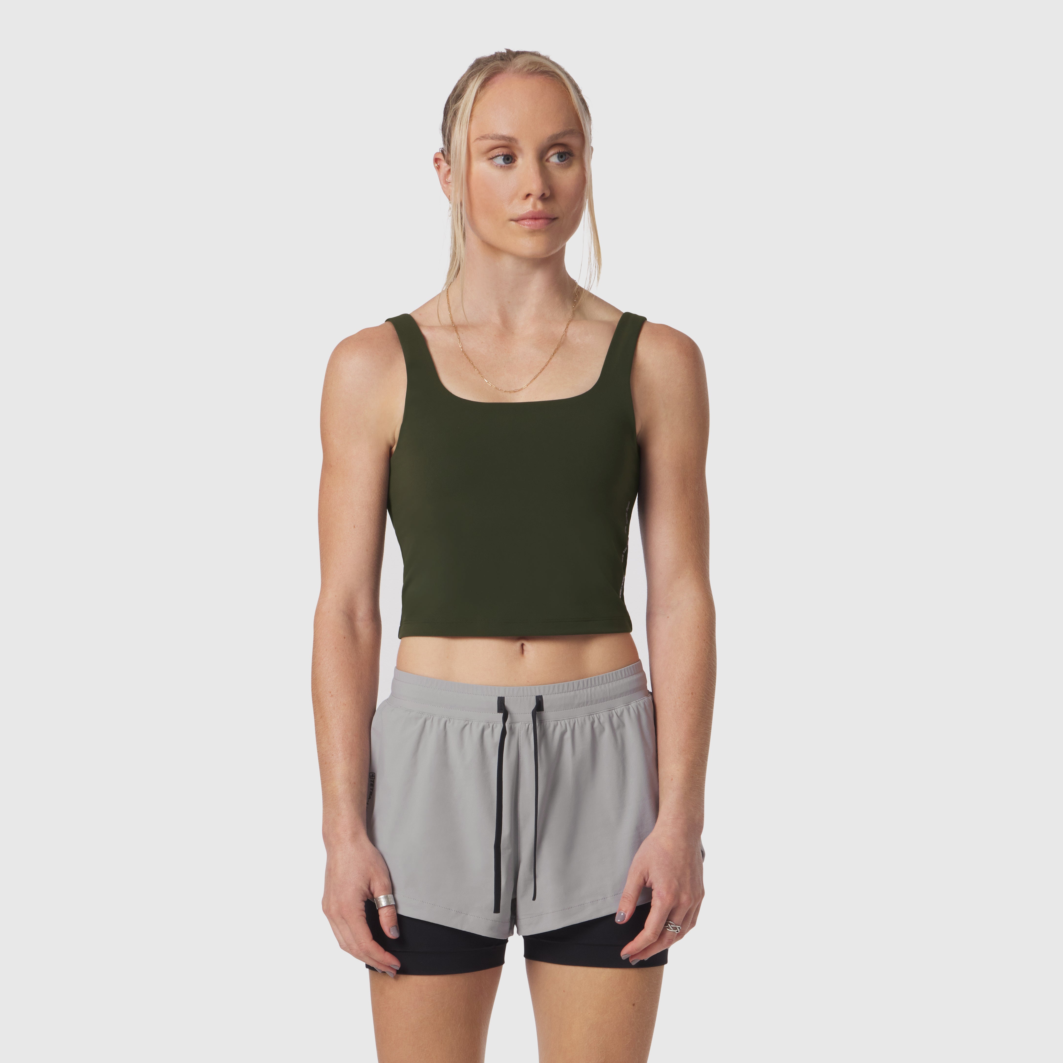 Olive LYCRA® 2-in-1 tank top worn with gray shorts, front view on model