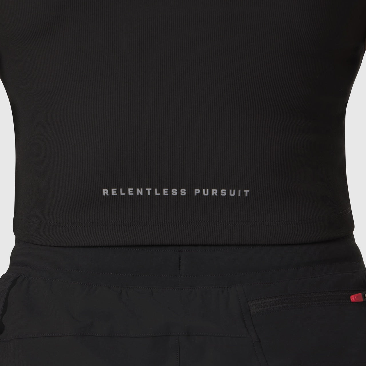 Black Lycra ribbed mockneck tank worn on model, front view showing 'Relentless Pursuit' text