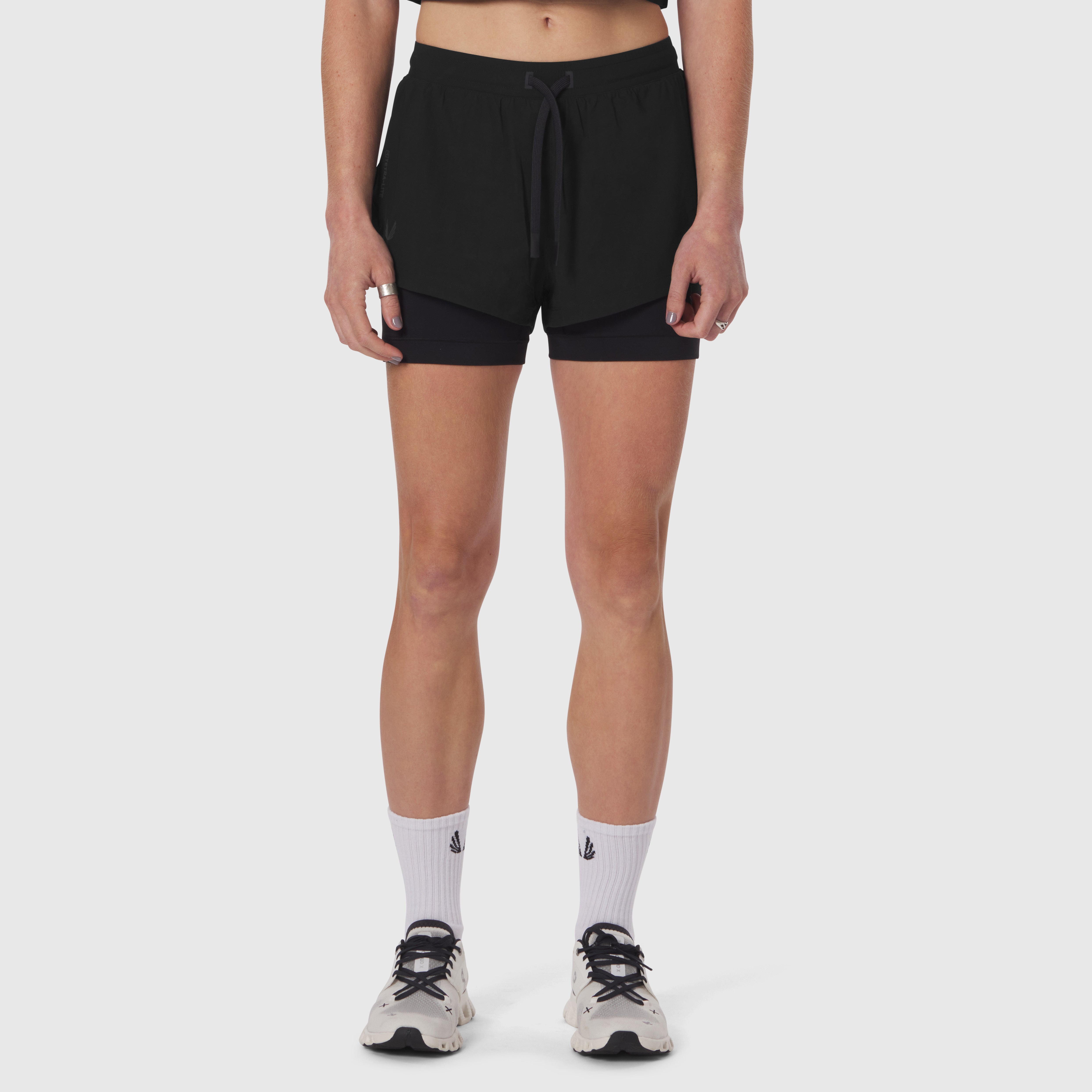 Black Tetra-Lite Liner Shorts worn by model with white socks and sneakers, front view