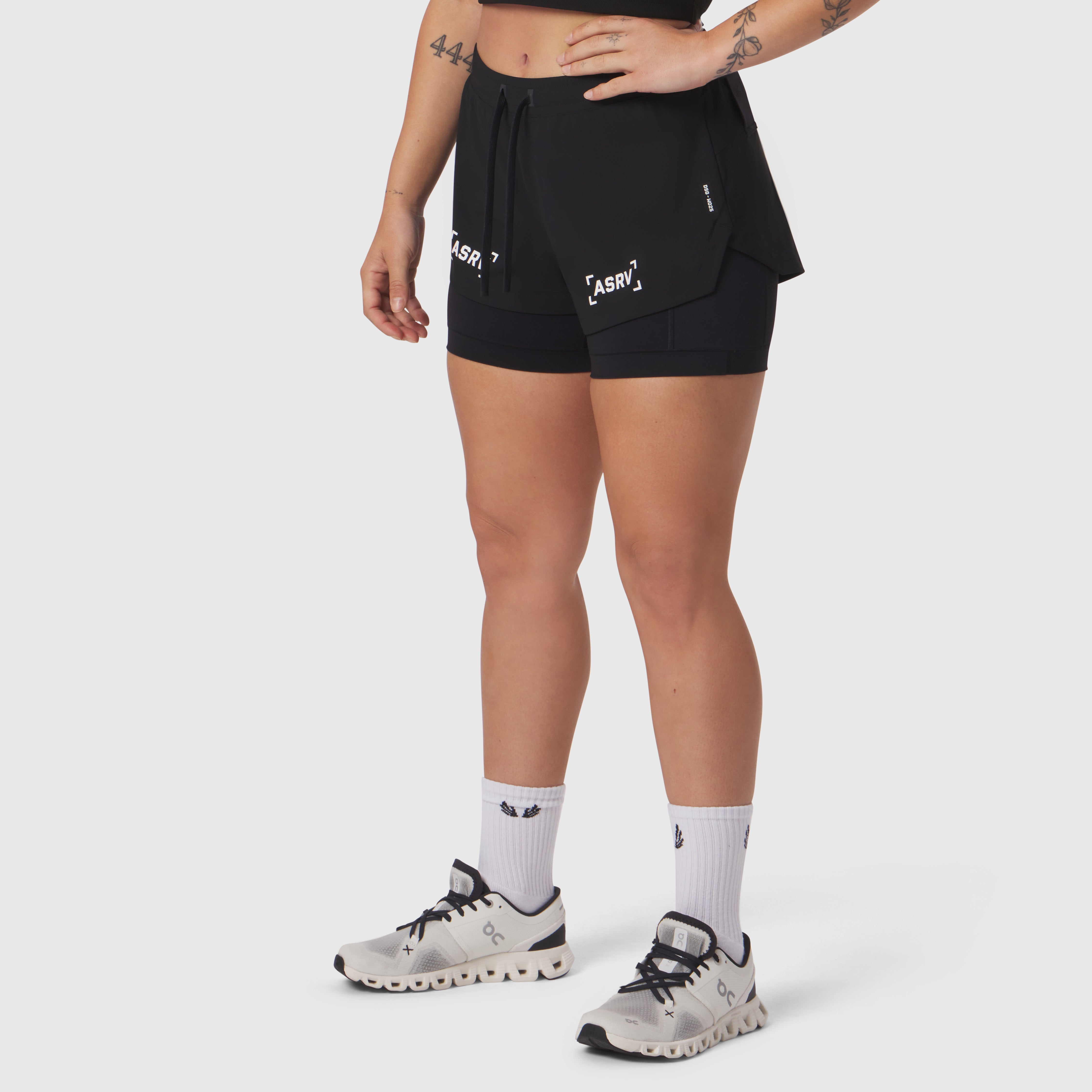 W025 Tetra-Lite Liner Short in black with bracket branding, worn by model with white socks and running shoes