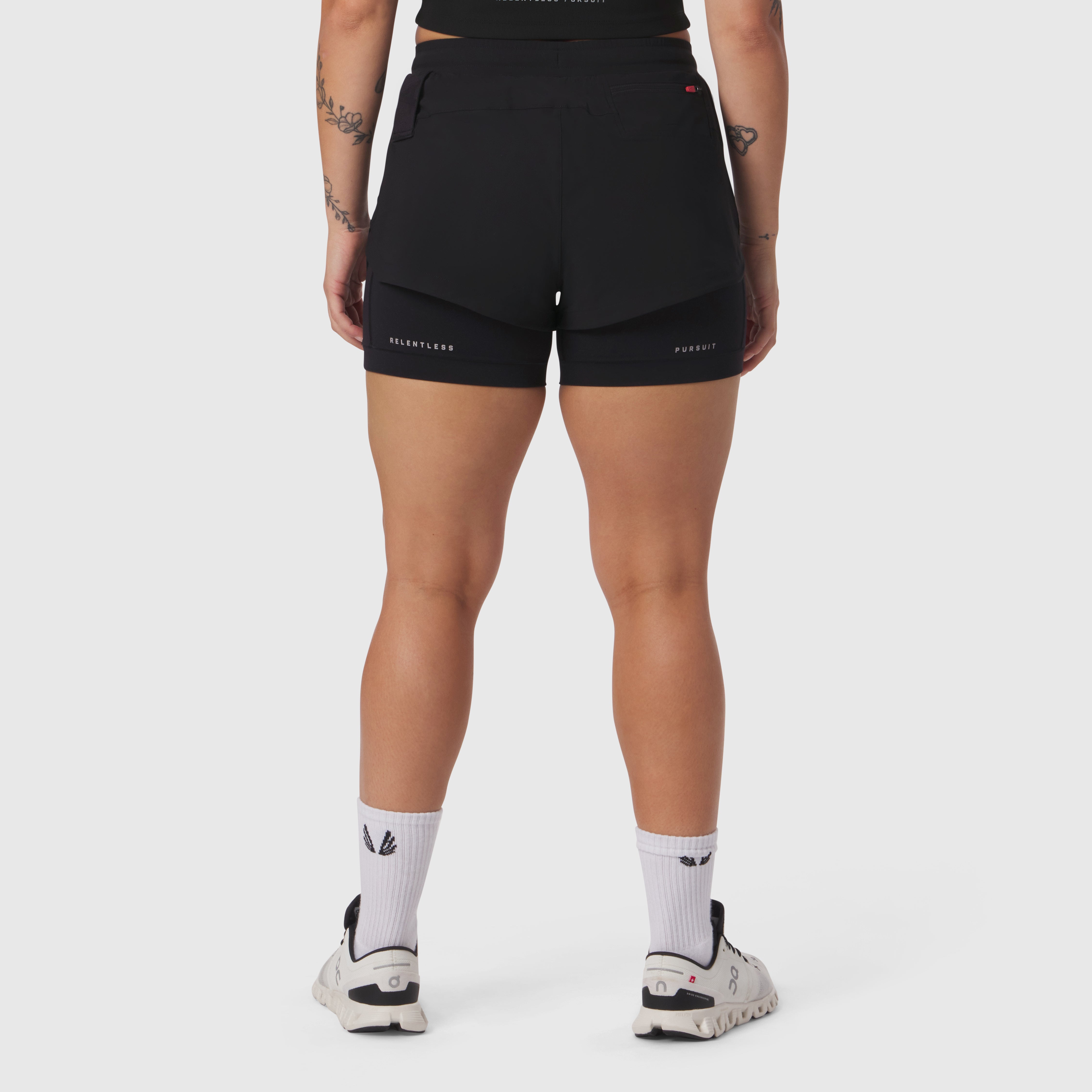 W025 Tetra-Lite Liner Short in black, rear view on model with white socks