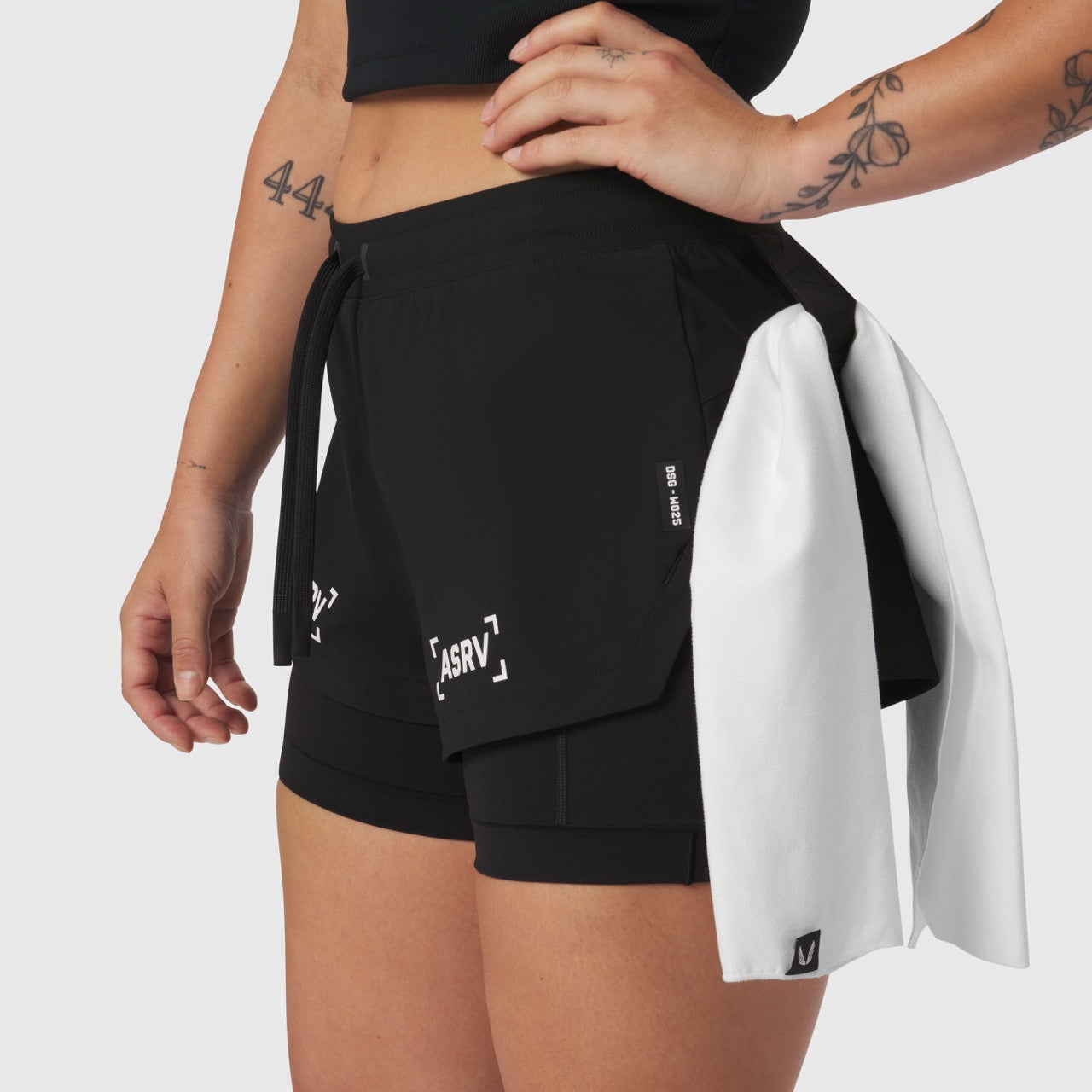 W025 Tetra-Lite Liner Short in black worn by model, front view with white jacket