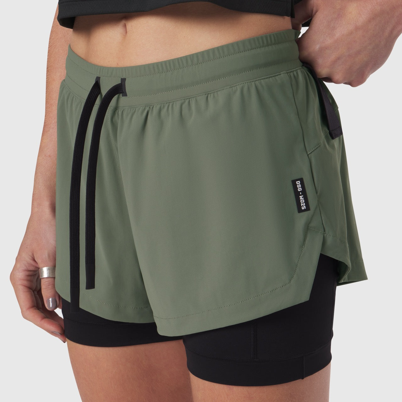 Tetra-Lite Liner Short in sage green with black shorts, worn by model, side view