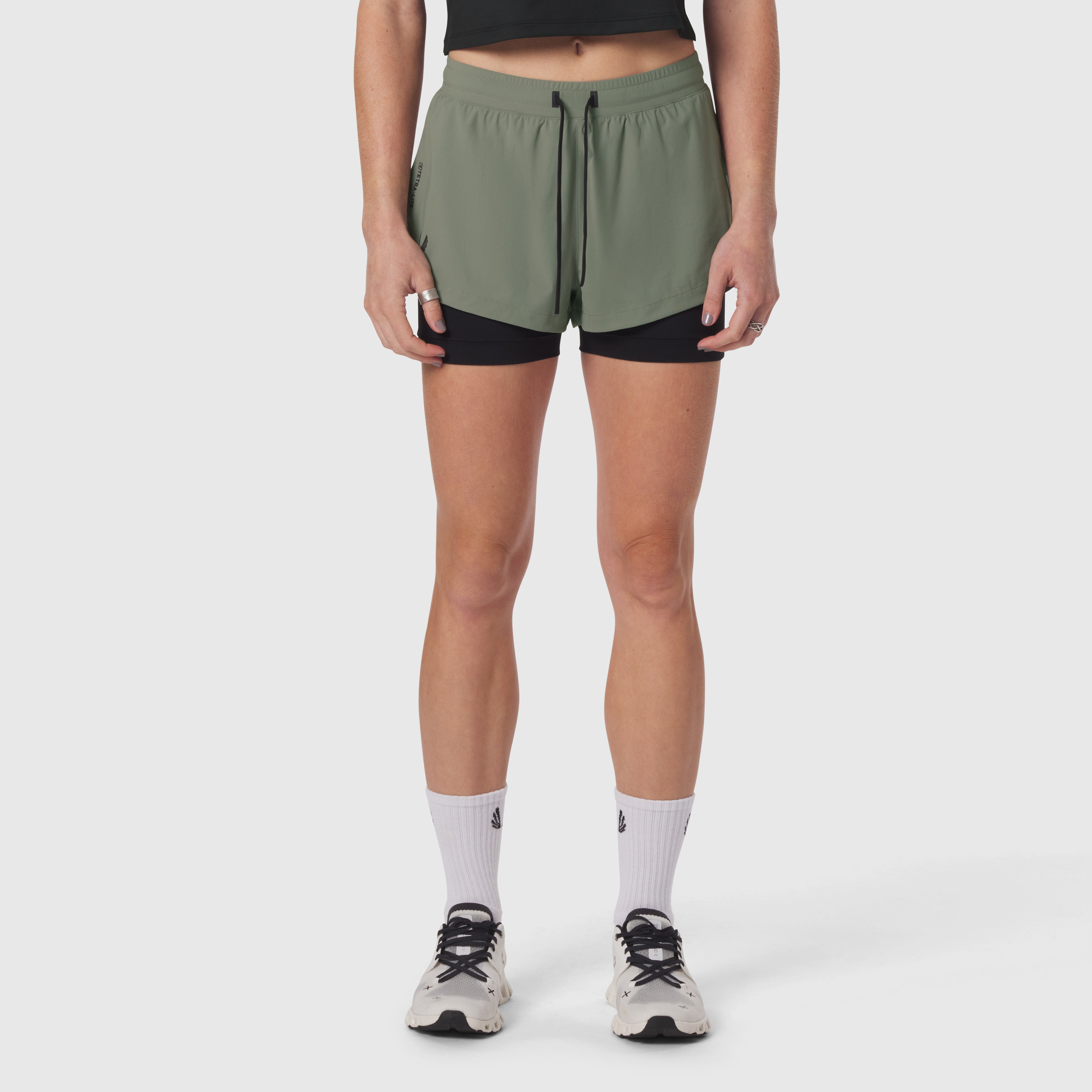 Tetra-Lite Liner Short in sage with black liner shorts, worn with white socks and sneakers