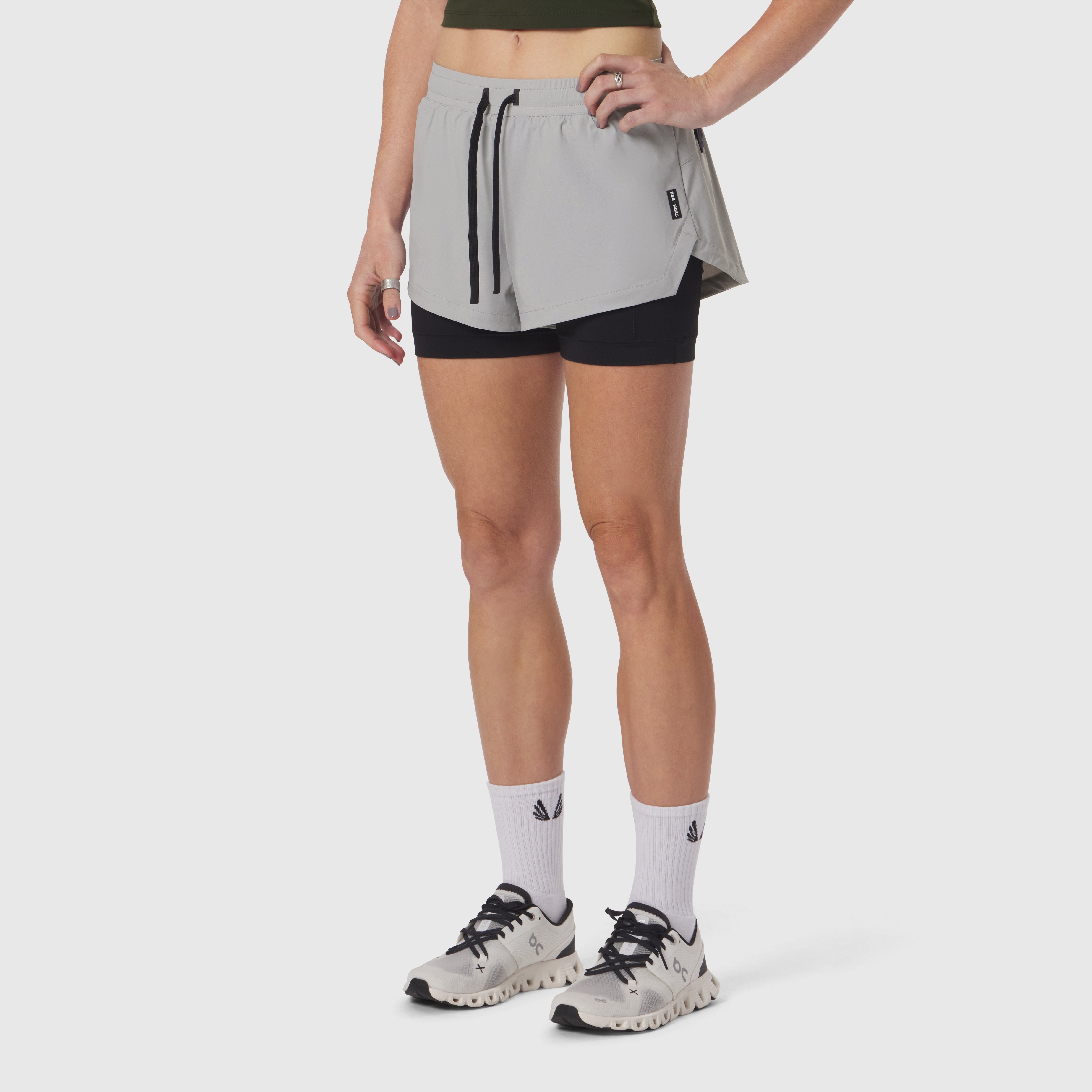 W025 Tetra-Lite Liner Short in slate grey and black, worn by model with white socks and trail shoes
