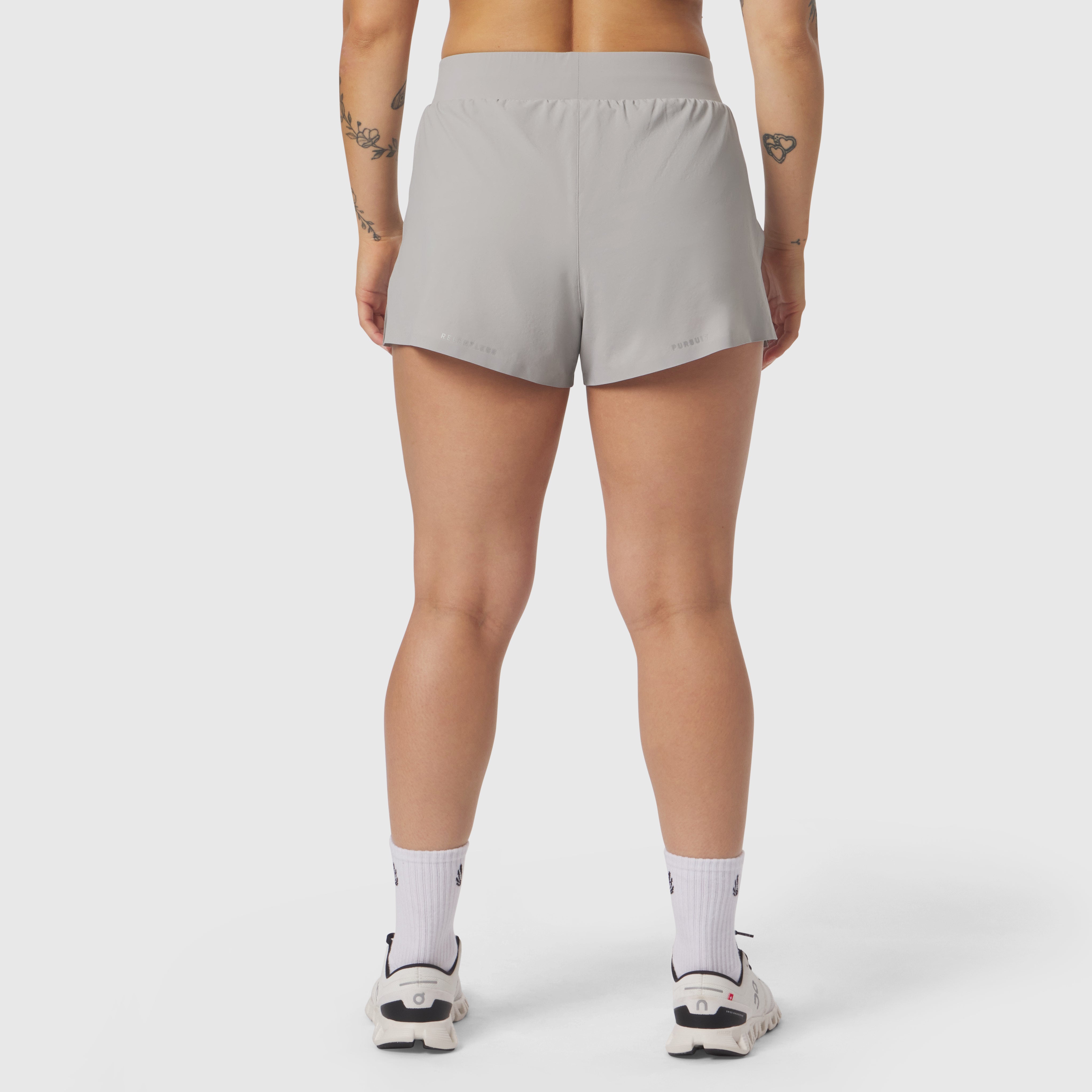Aerotex Side Split Run Short in slate grey, back view on model with white socks and sneakers