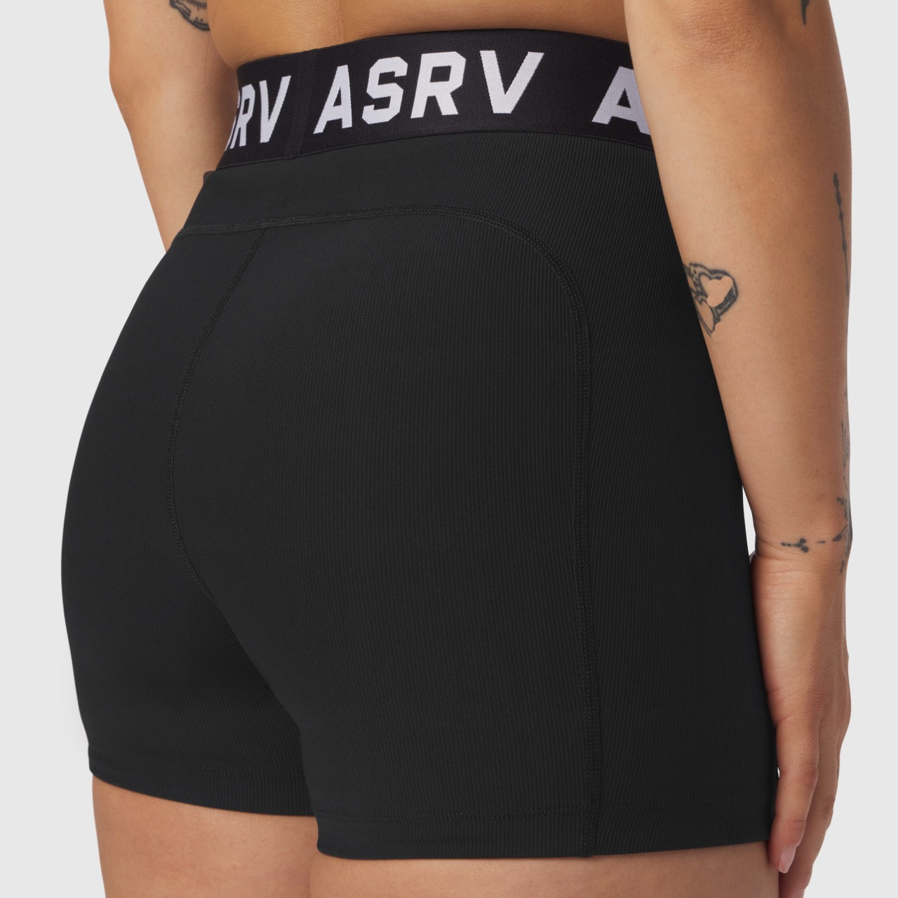 Black LYCRA® ribbed shorts on model, rear view, showing fit and waistband detail