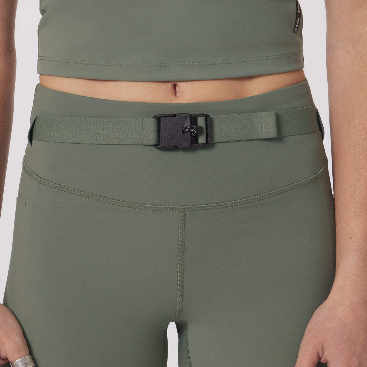 LYCRA® 3-in-1 biker short in sage, worn with matching crop top and belt, front view