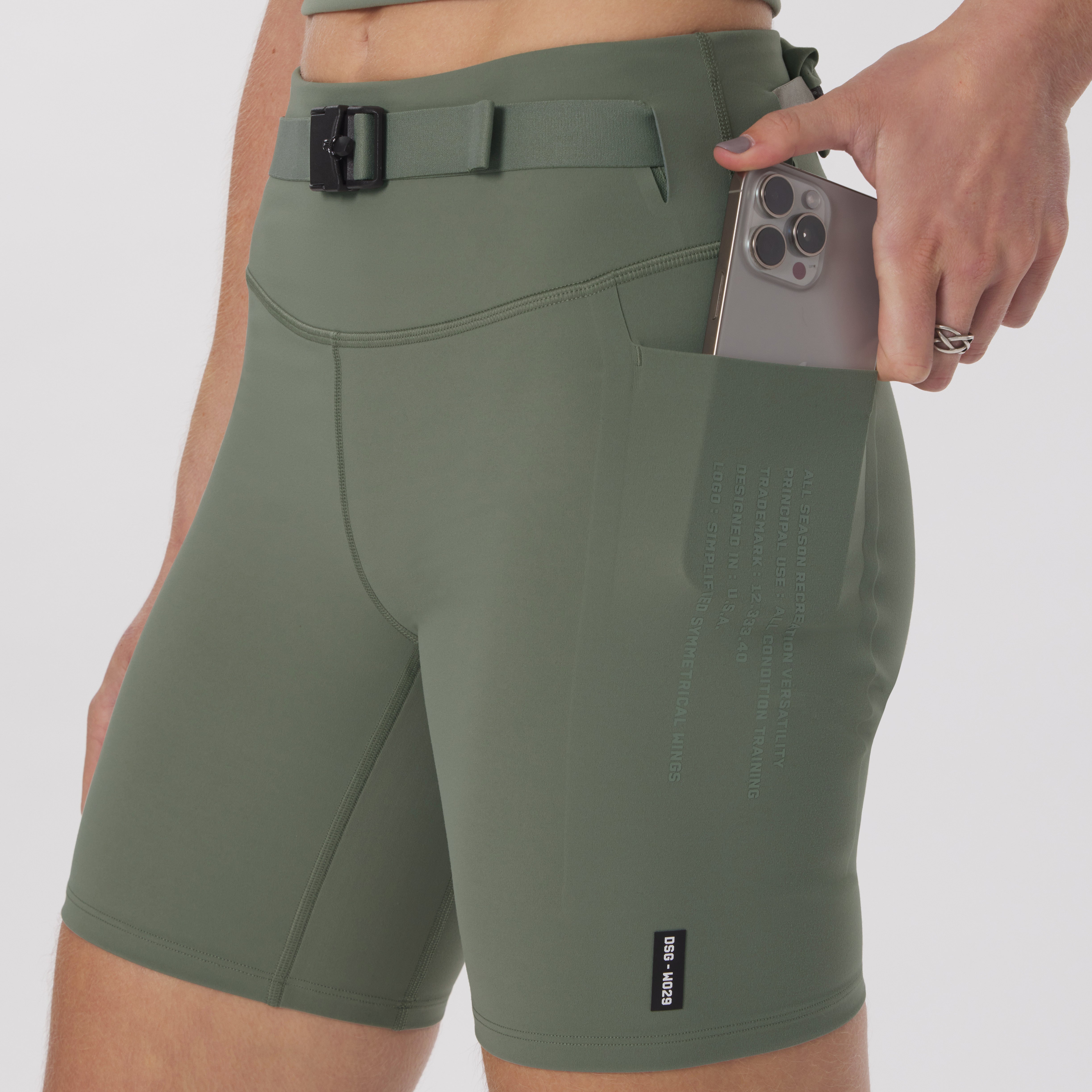 LYCRA® 3-in-1 Biker Short in sage worn by model, holding phone in pocket