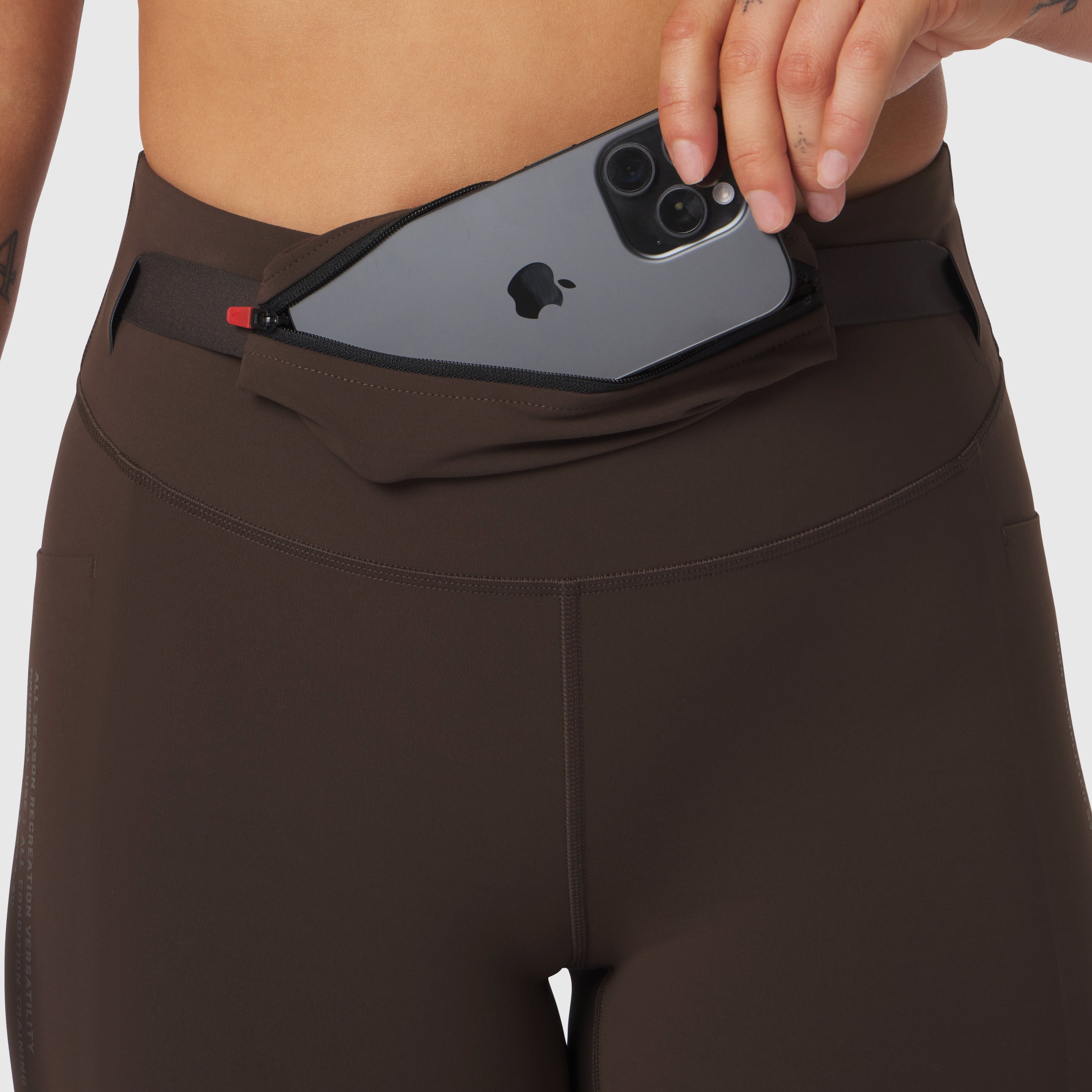 W030 Lycra 3-in-1 Legging in Dark Earth, worn with phone in waistband pocket