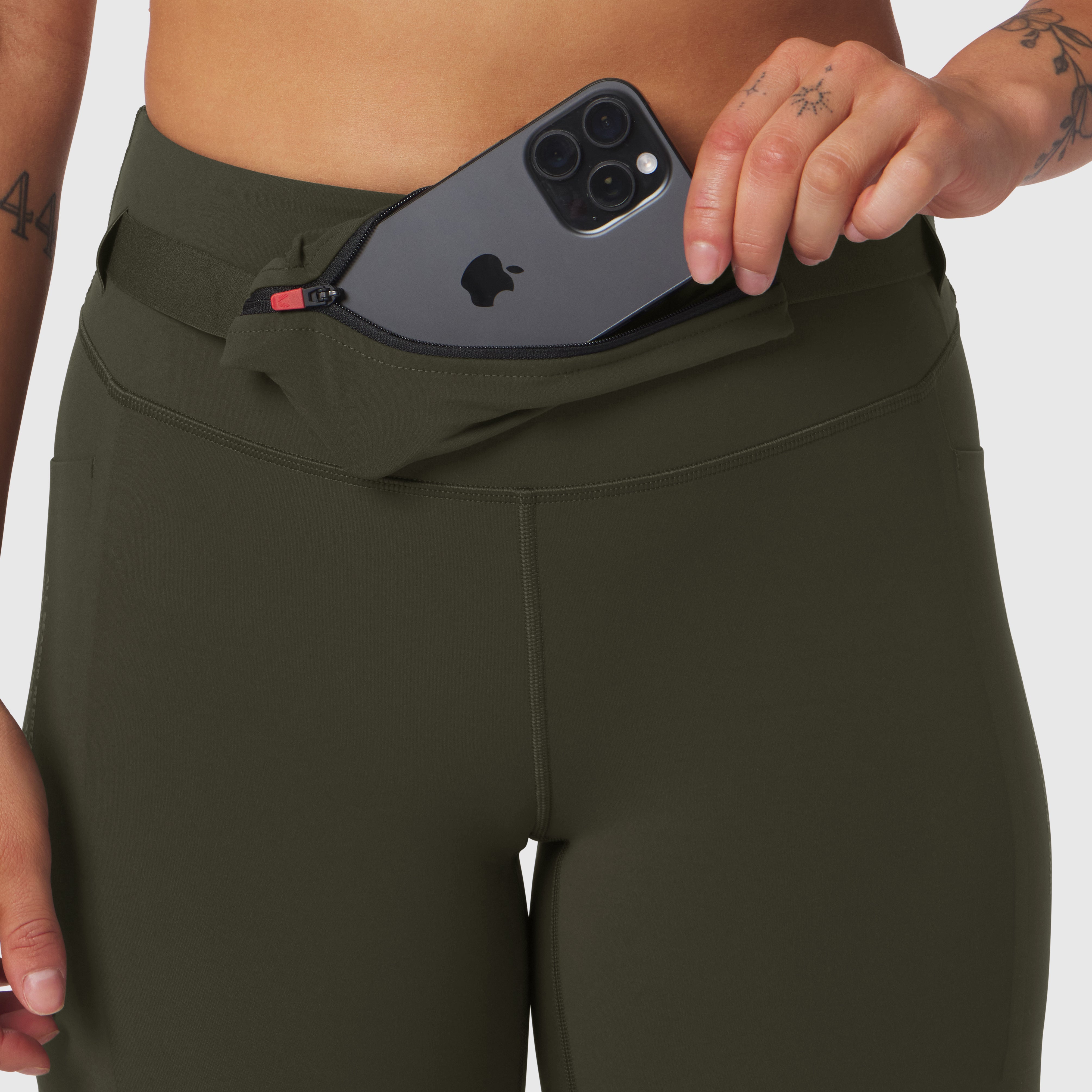 W030 Lycra 3-in-1 legging in olive worn by model, demonstrating pocket detail with phone