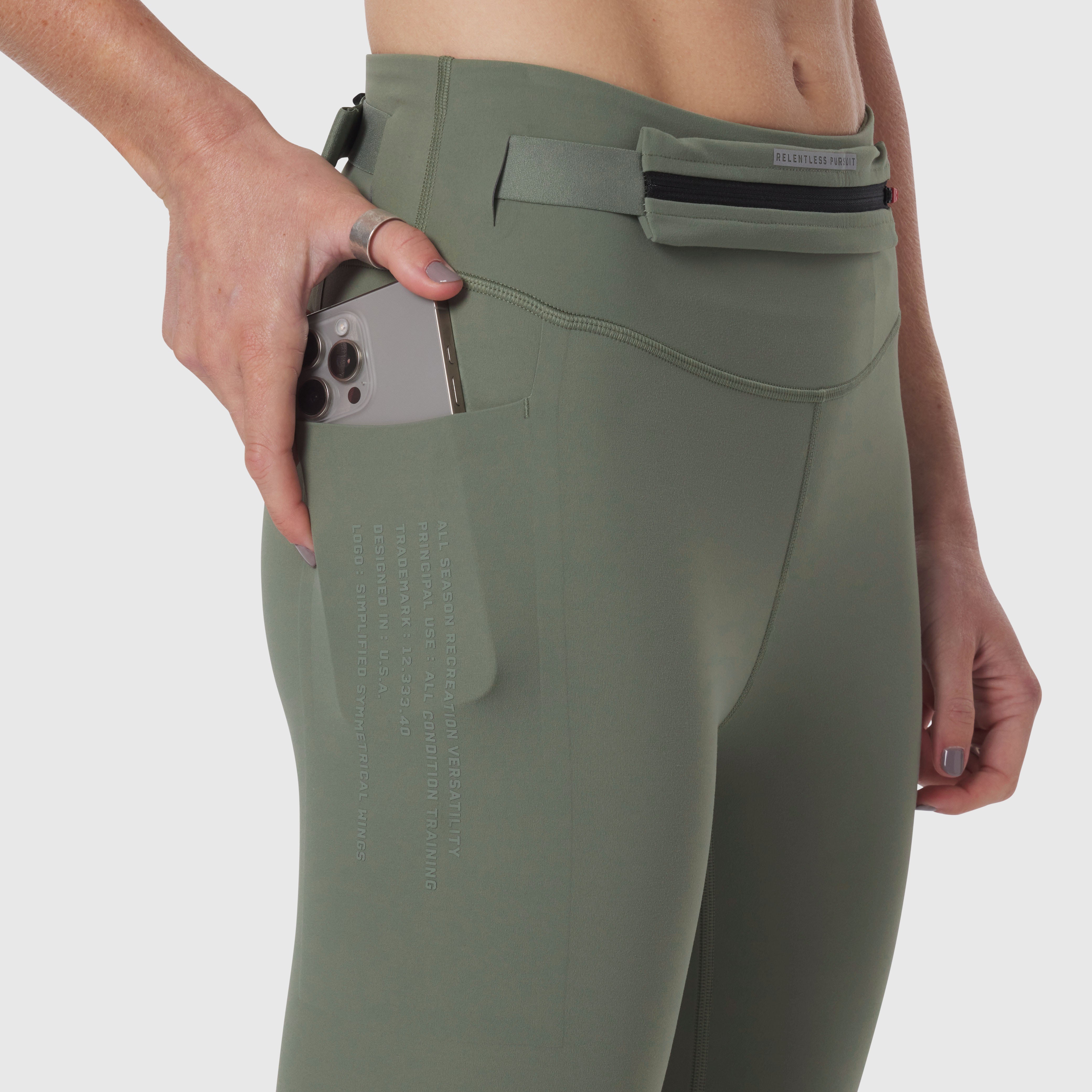 W030 LYCRA® 3-in-1 Legging in sage, model holding phone in side pocket