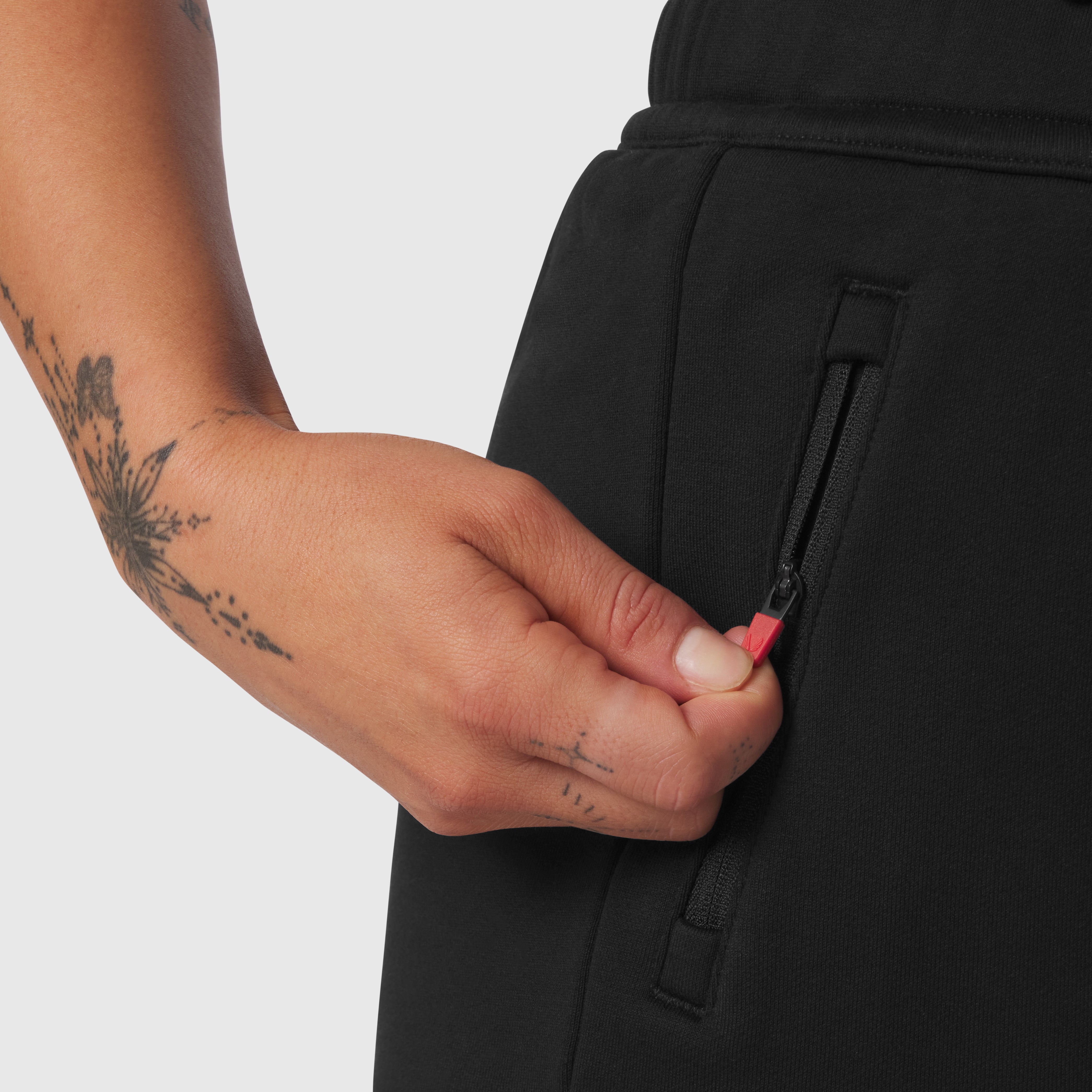 Black Sorona® Terry straight leg sweats worn by model, detail of hand and zipper pocket