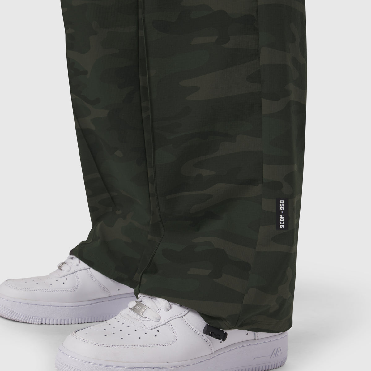 W036 Ripstop Relaxed Track Pant in Dark Camo worn with white sneakers, lower body view