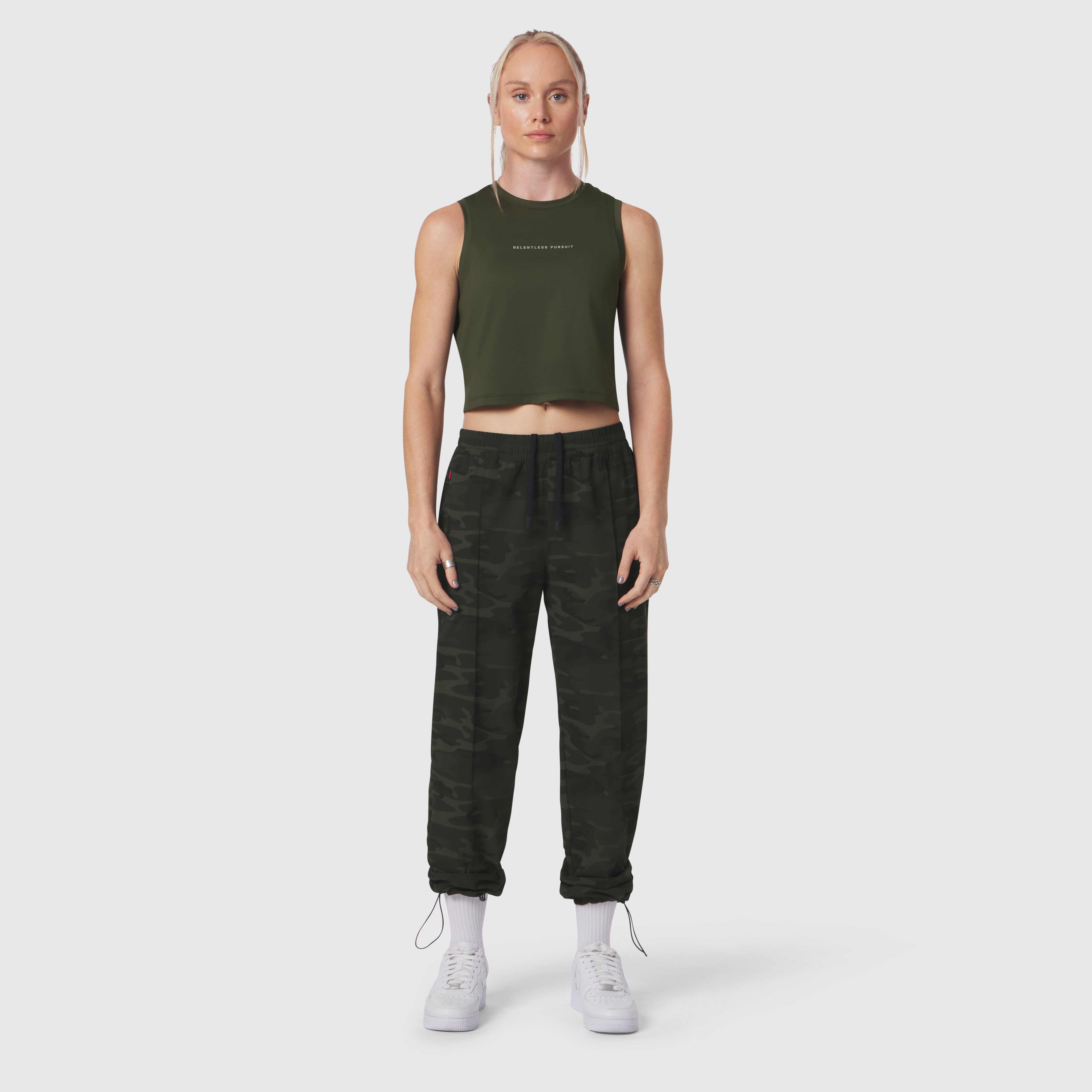 W036 Ripstop Relaxed Track Pant in dark camo, worn with olive crop tank top and white sneakers