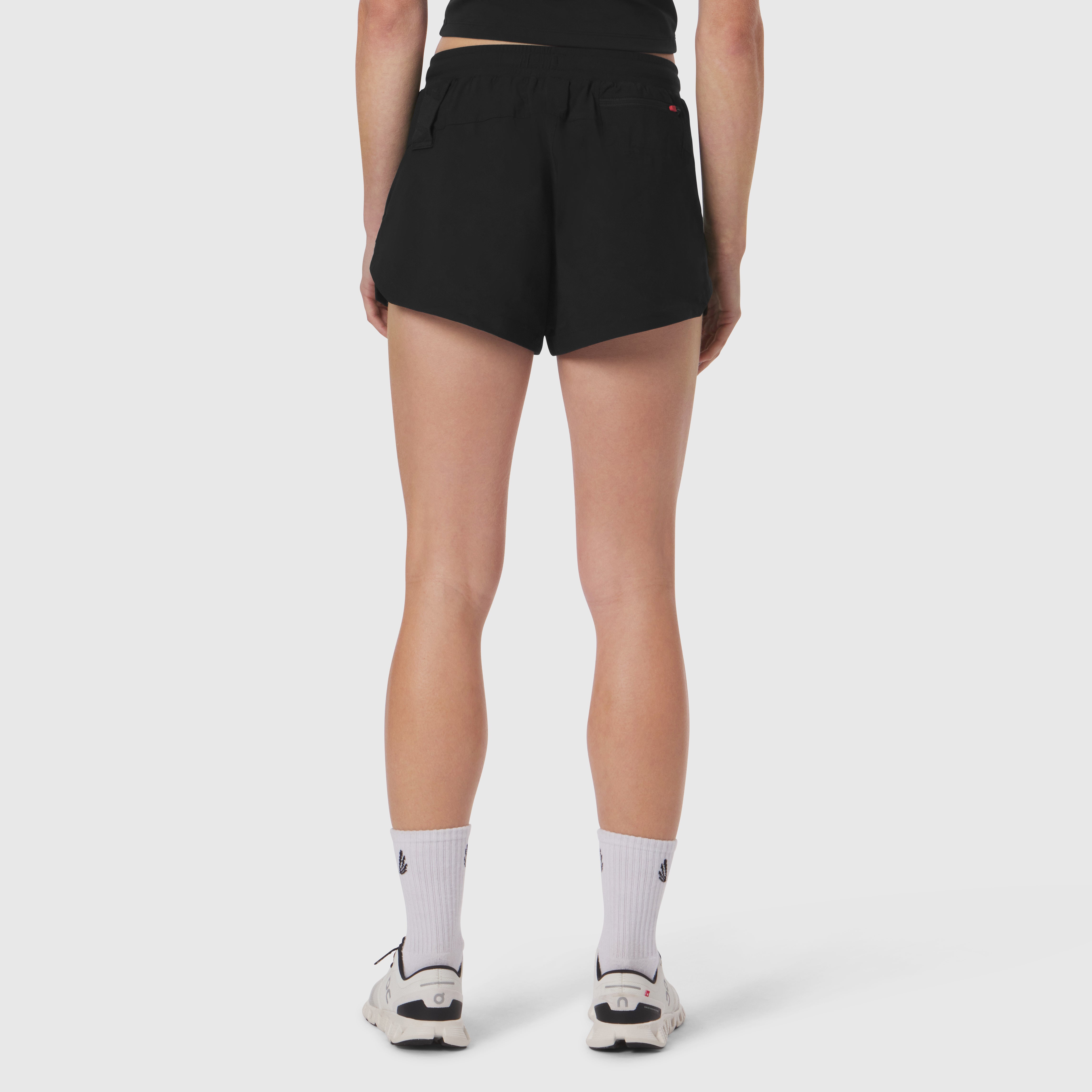 Black Tetra-Lite Linerless Shorts worn by model, back view with white socks and sneakers