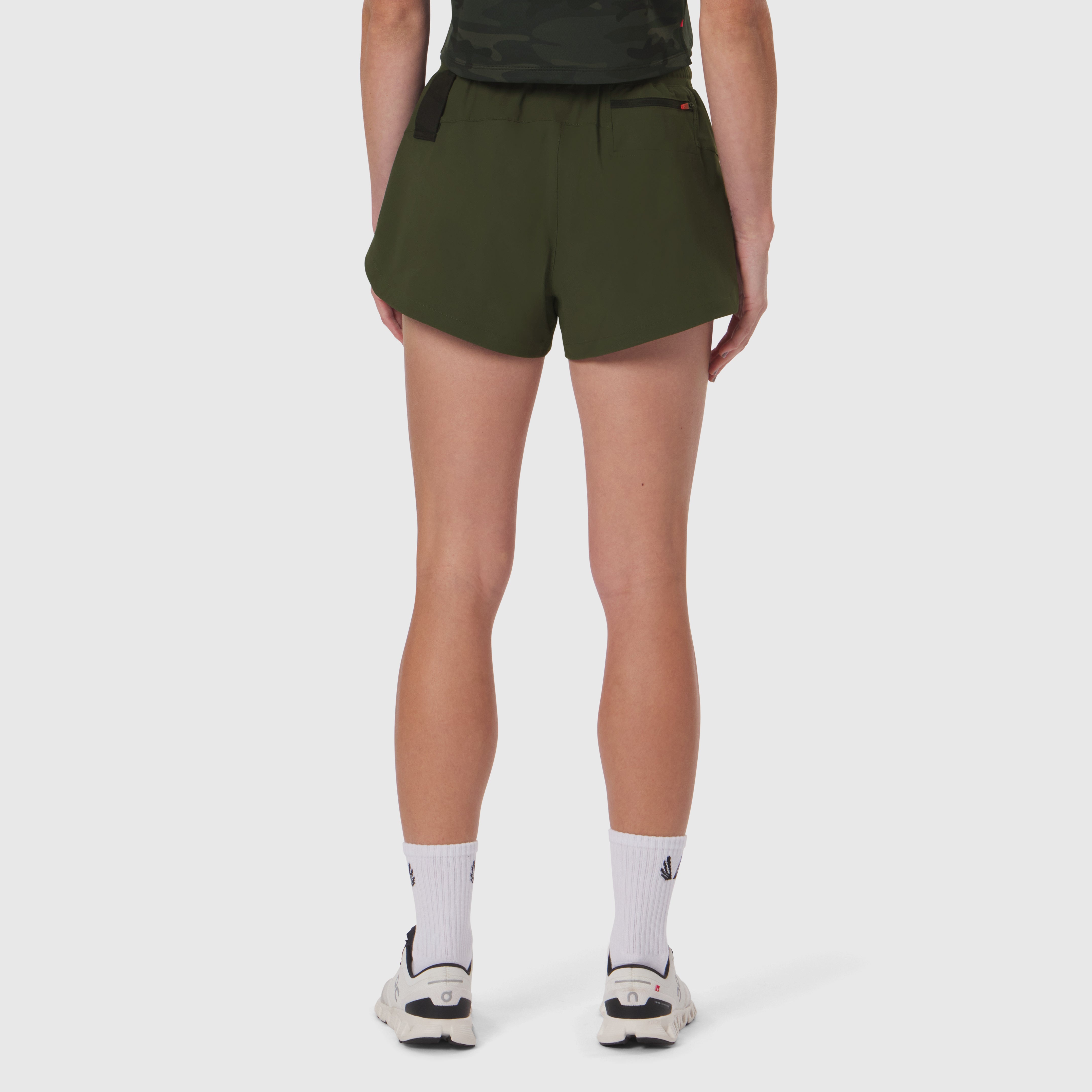 Tetra-Lite Linerless Short in olive worn by model from behind, paired with white socks and sneakers
