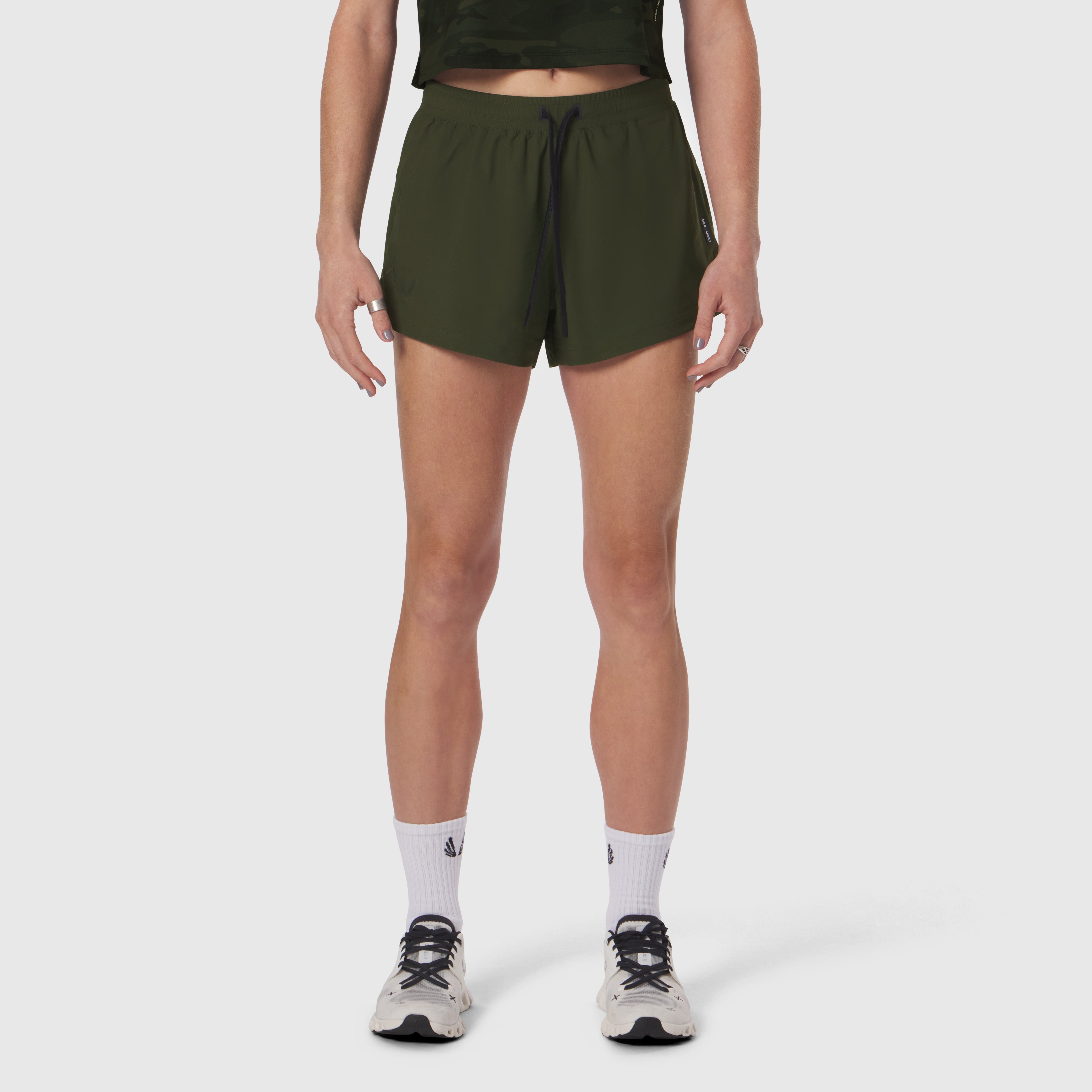 Tetra-Lite Linerless Short in olive, worn by model with white socks and sneakers
