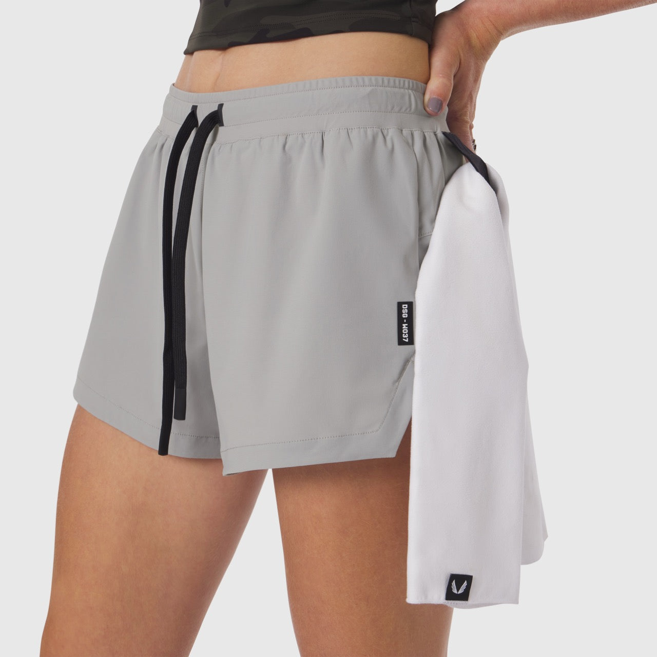Tetra-Lite Linerless Short in slate grey and white, worn by model with towel accessory