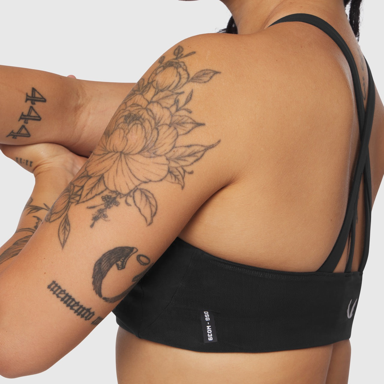 Black Lycra Hybrid Sports Bra worn by model with visible tattoos, back view