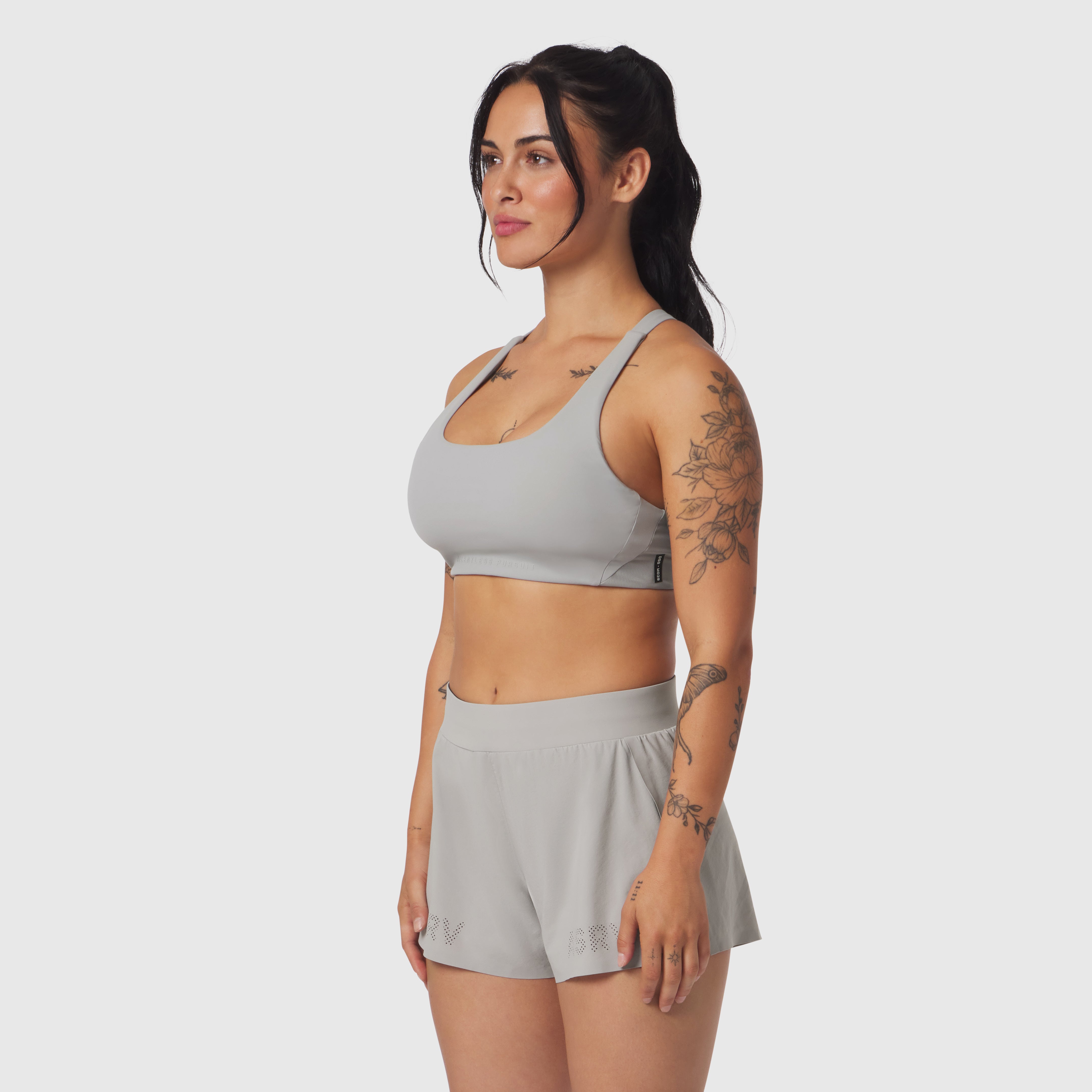 Lycra Hybrid Sports Bra in slate grey, worn by model in side profile pose