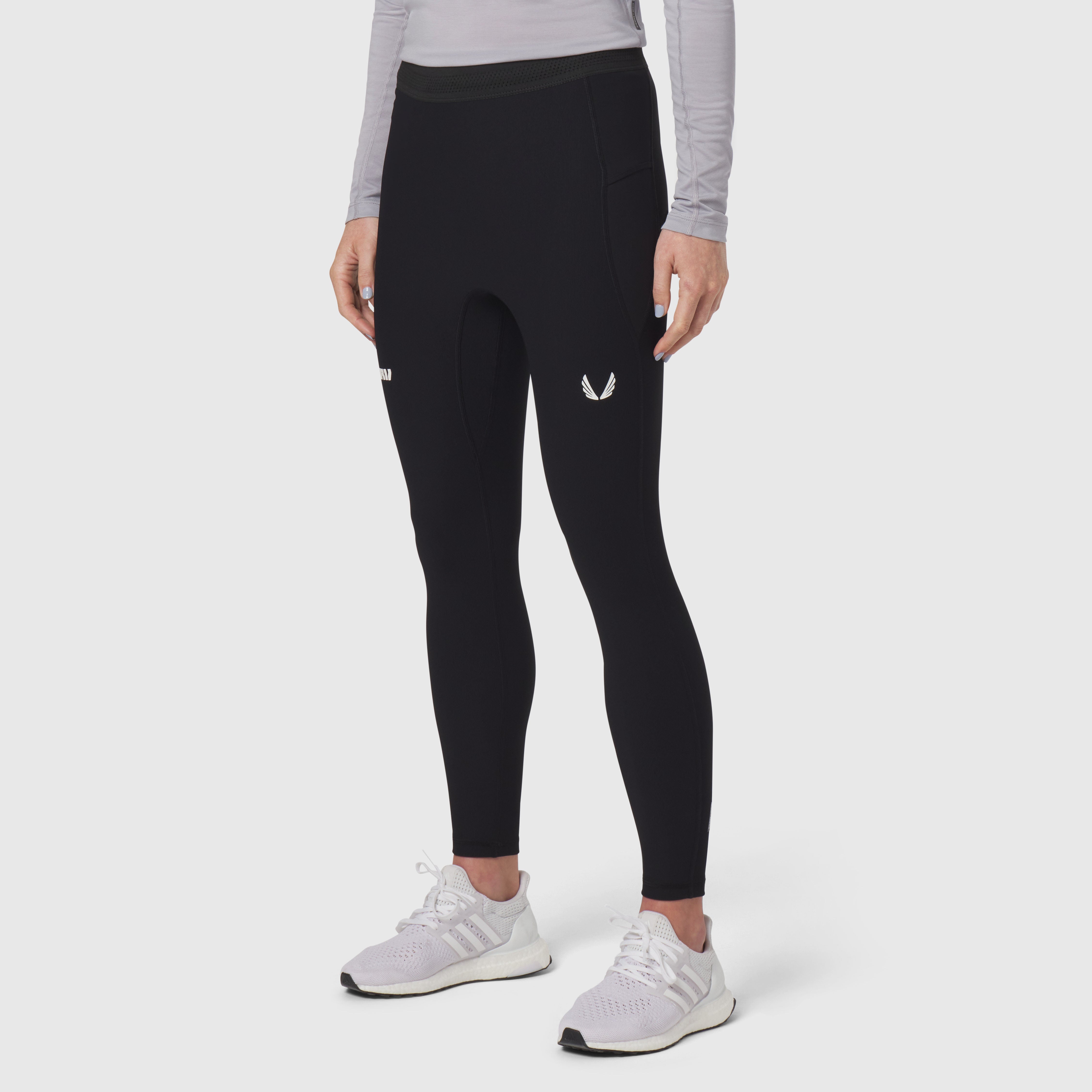 Black Lycra ribbed running tight on model, front view with white sneakers