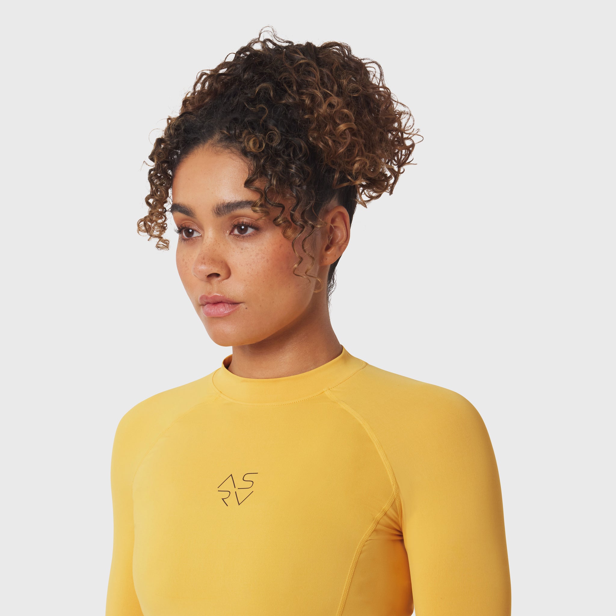 LYCRA® ADAPTIV Baselayer Longsleeve in amber yellow, worn by model, front view