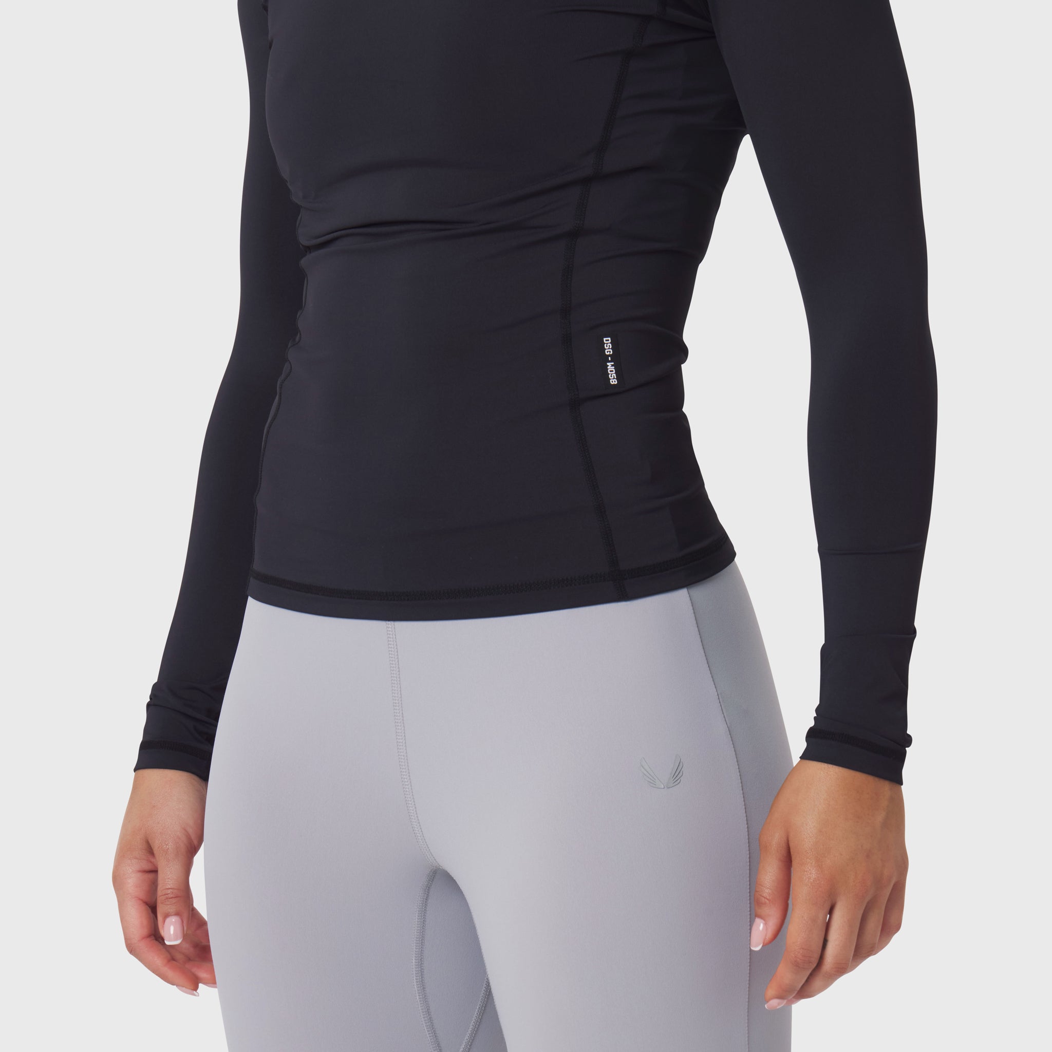 LYCRA® ADAPTIV Baselayer Longsleeve in black, worn with grey leggings, side view