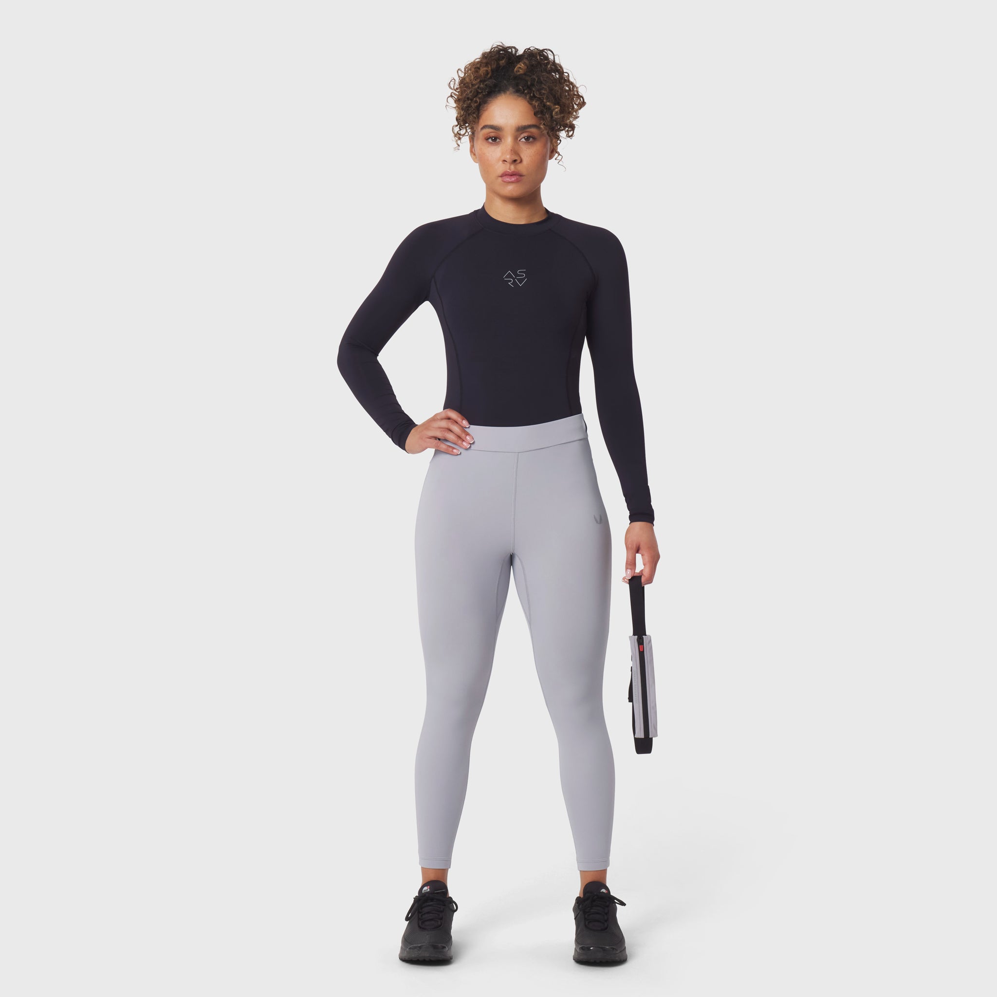 Black LYCRA® ADAPTIV baselayer longsleeve worn with grey leggings, front view