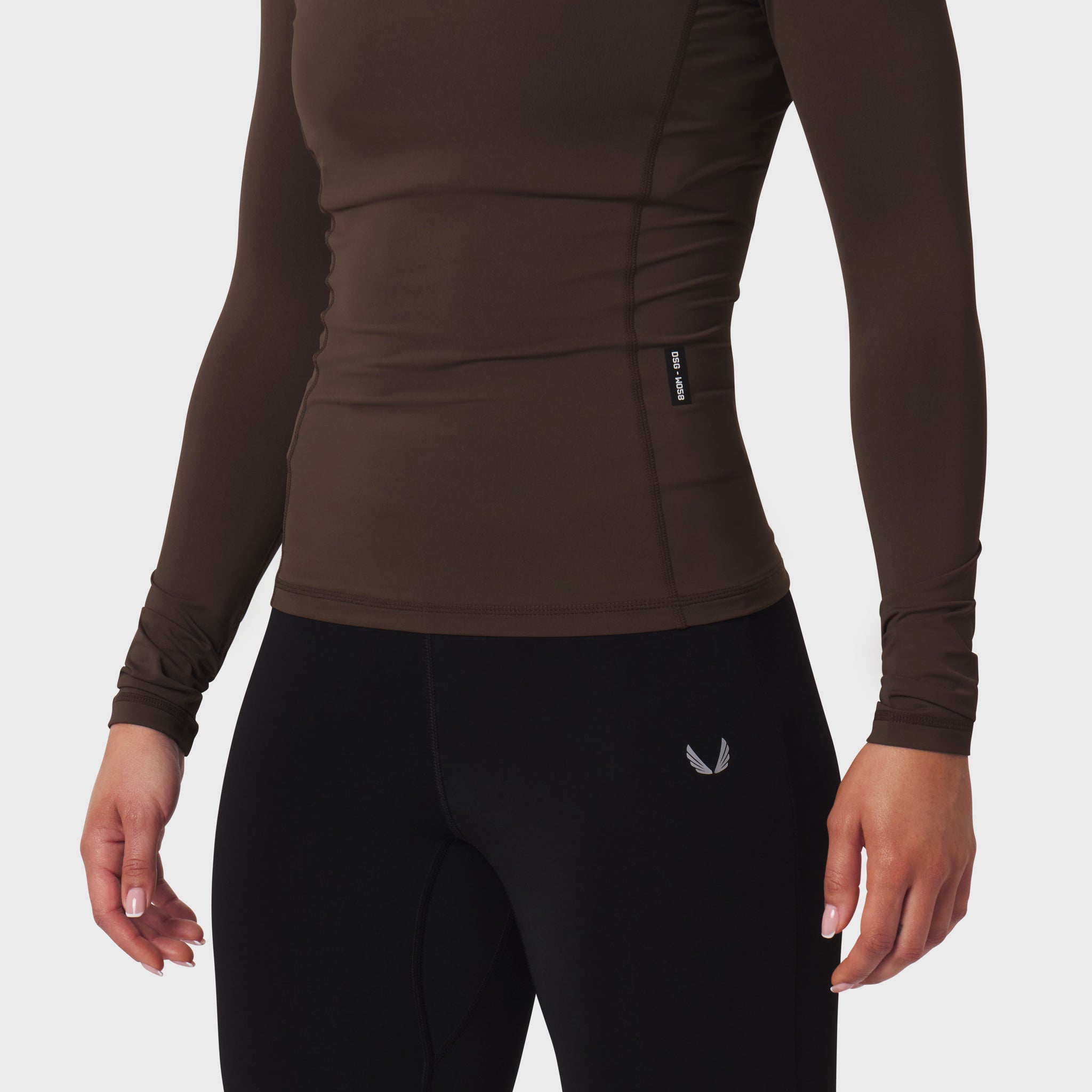 LYCRA® ADAPTIV Baselayer Longsleeve in dark earth, worn with black leggings, back view