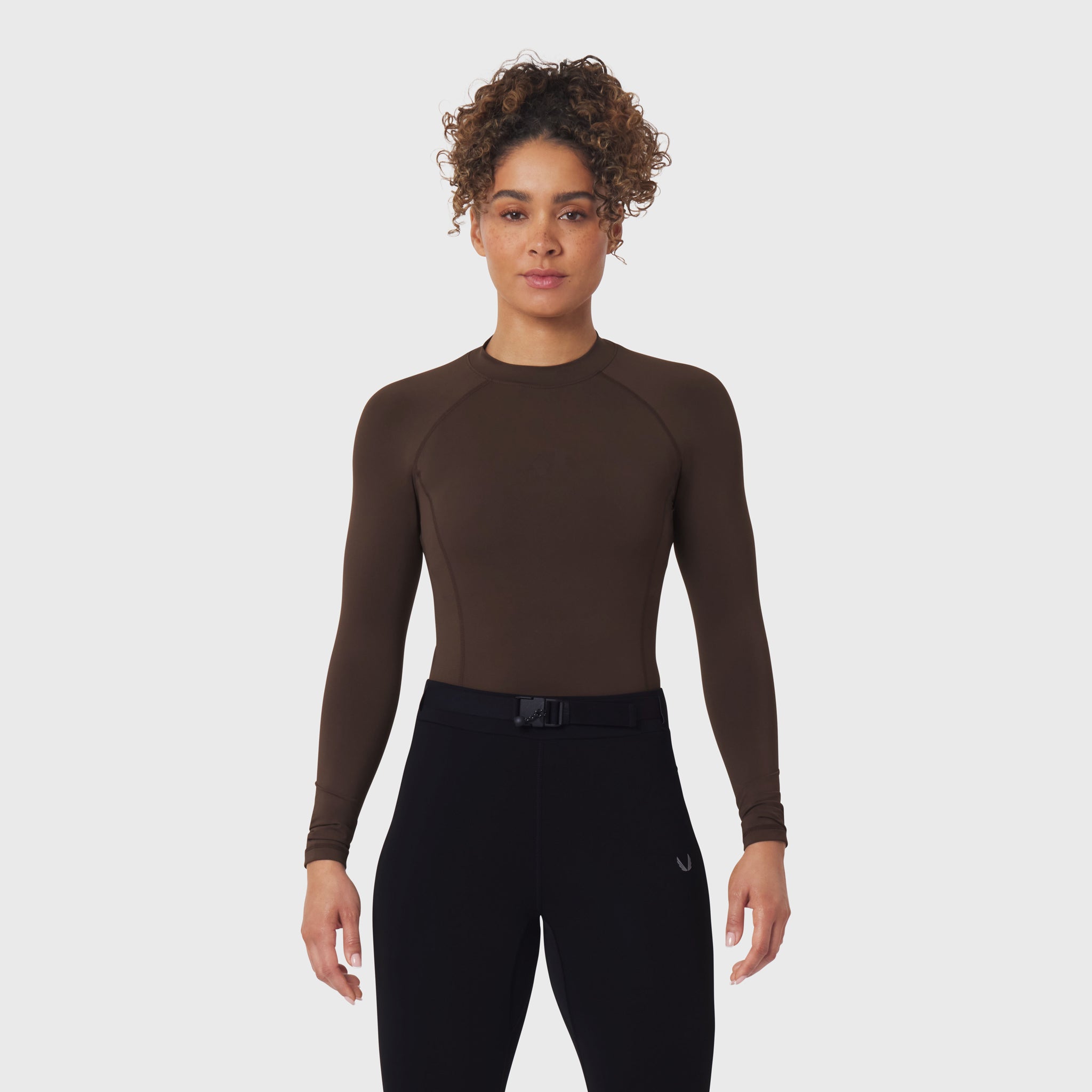 LYCRA® ADAPTIV Baselayer Longsleeve in Dark Earth, worn with black leggings, front view